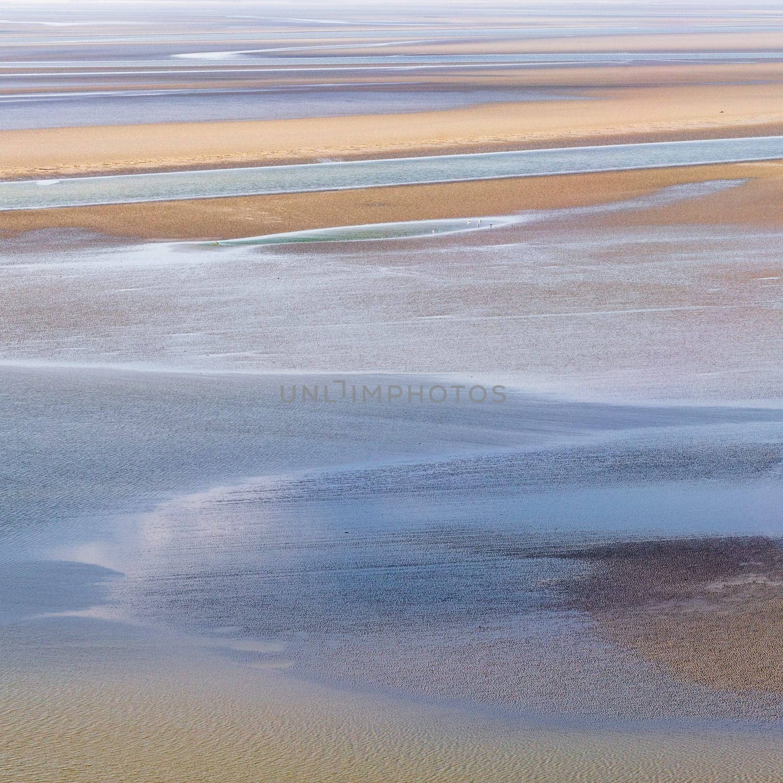 flowing sea water on sand at low tide in the bay of Mont Saint-Michel, abstract composition