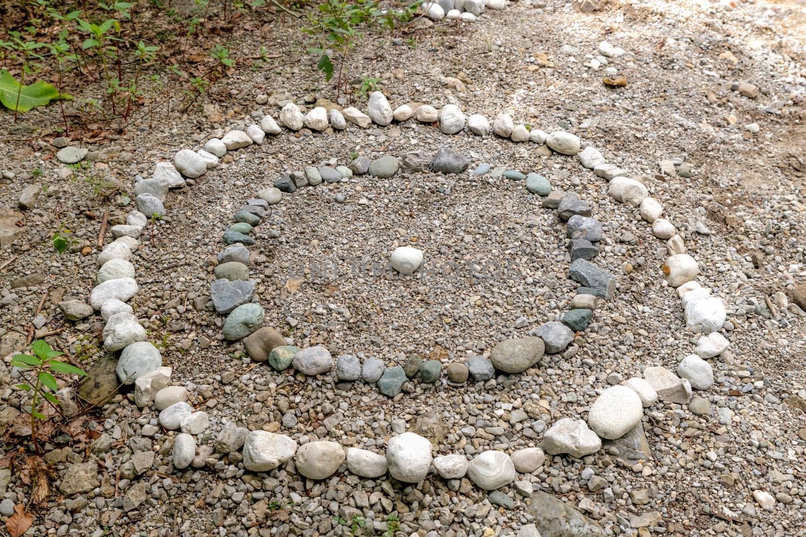 Circles of white and gray pebbles on the bank of a stream