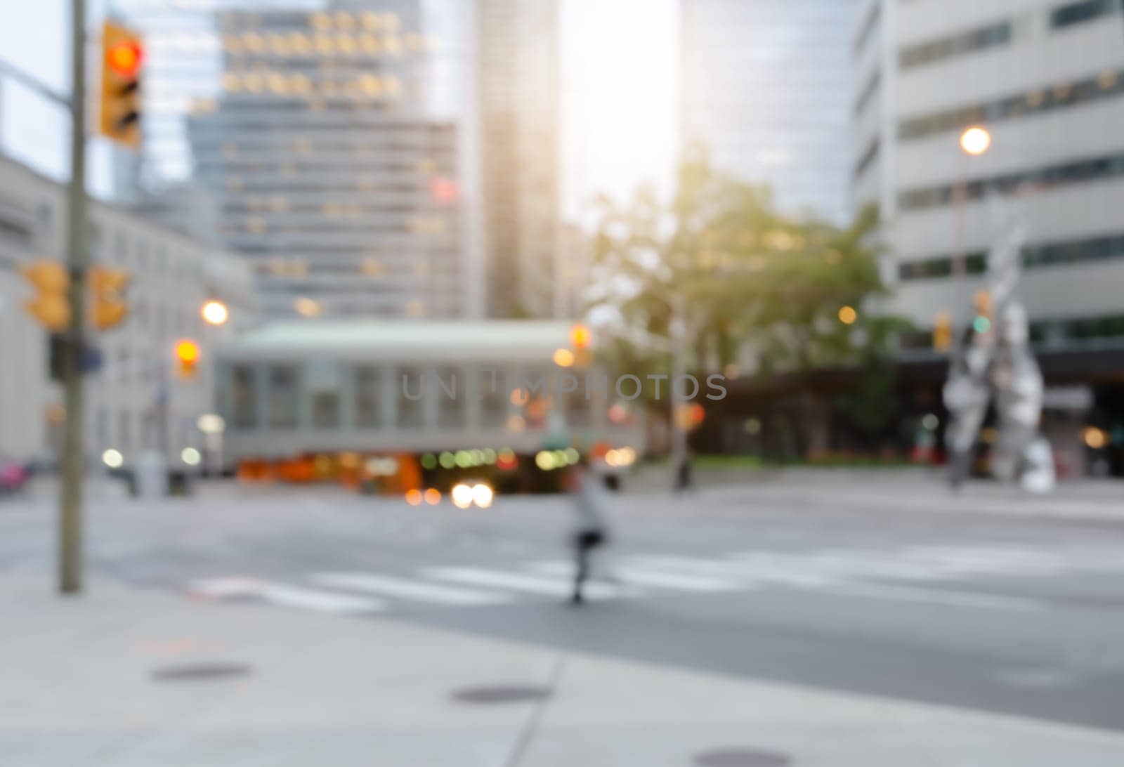 Blurred a man crossing the street in the city with traffics light bokeh and buildings for background