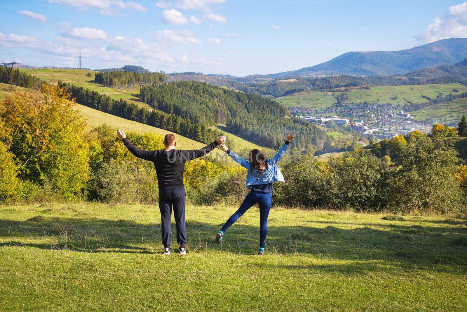 Summer landscape in the mountains and a beautiful blue sky with clouds-a loving couple sitting on the background.