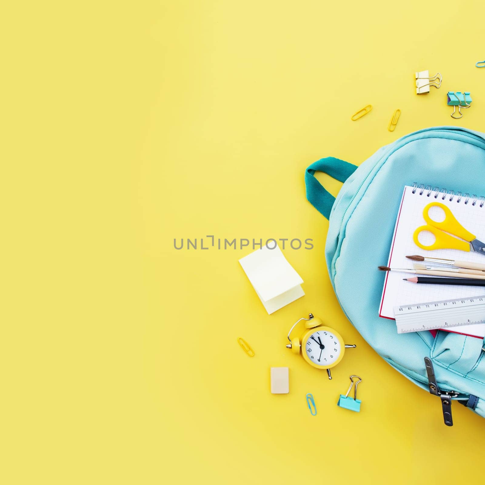 Back to school conceptual flat lay with different office supply items and copy space area for text. Concept for primary and secondary school pupil. Pupil blue back pack bag with variety office supply