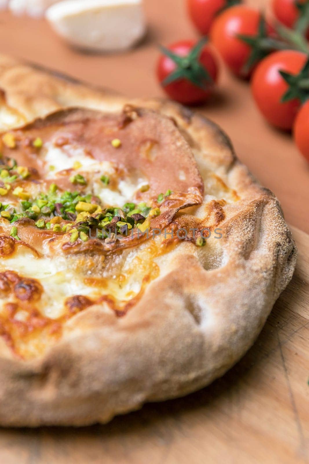 Delicious gourmet pizza with ham, and pistachios.