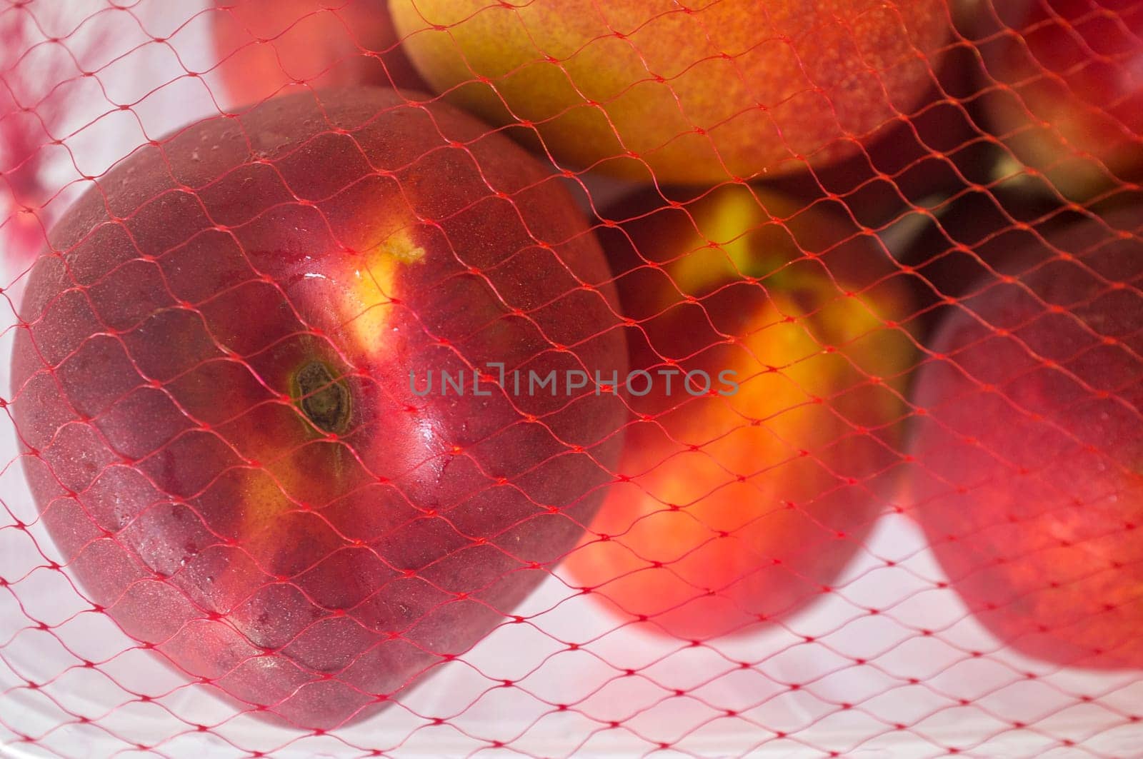 Nectarines on their plastic package covered. Closeup