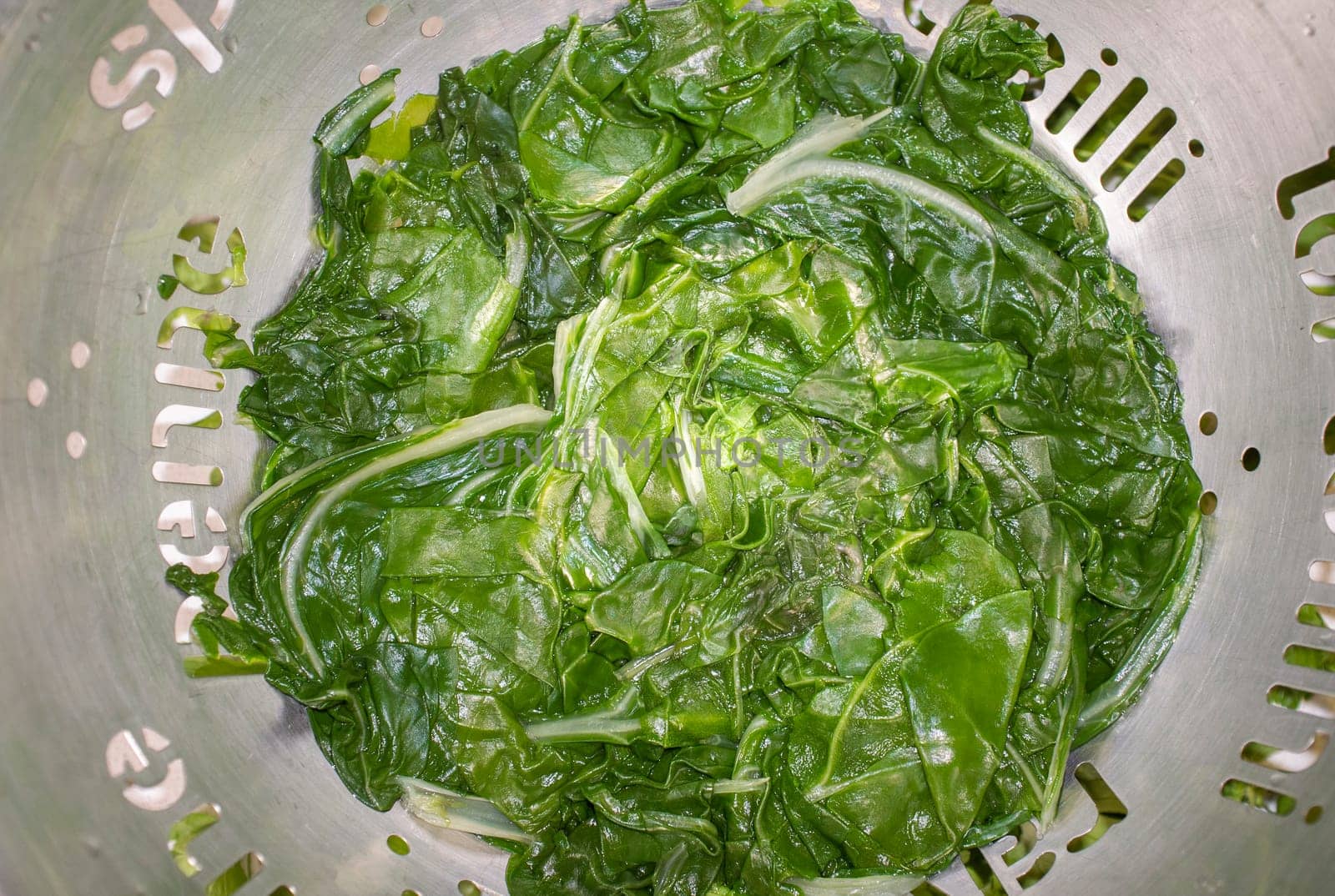 Boiled spinach on colander. Selective focus