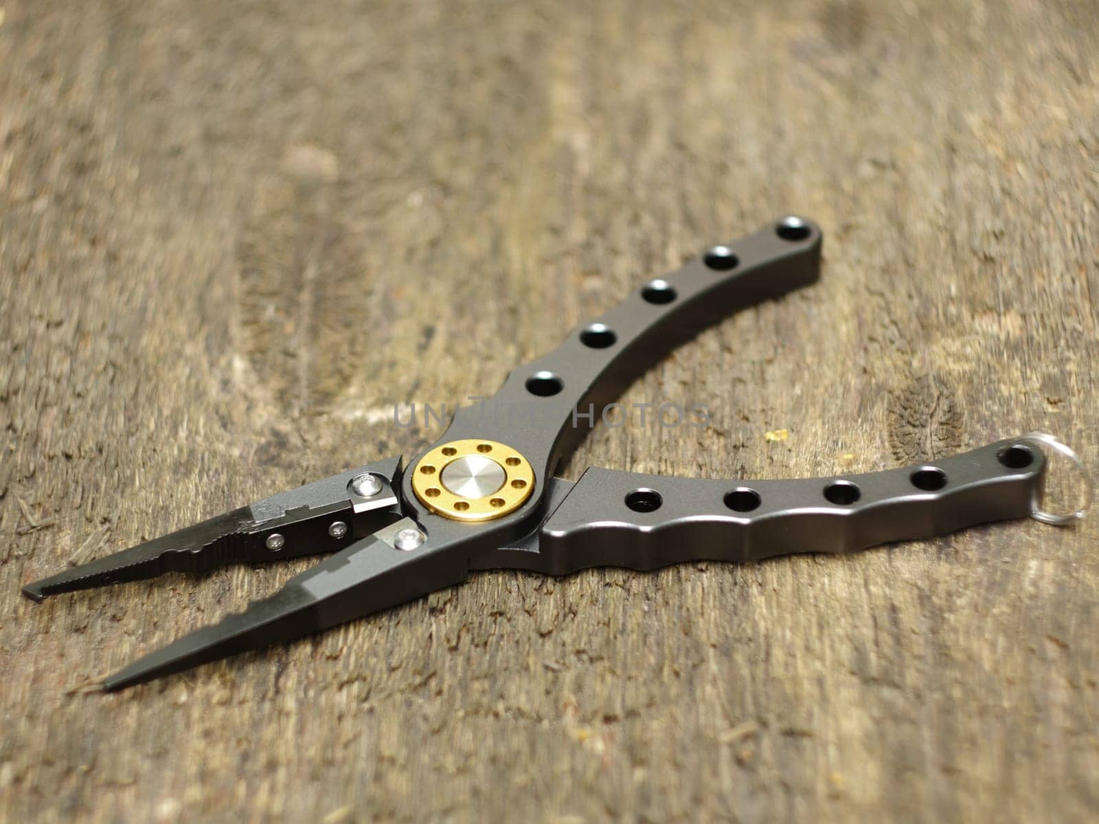 pliers with sharp nippers and narrow jaws on wooden background close-up