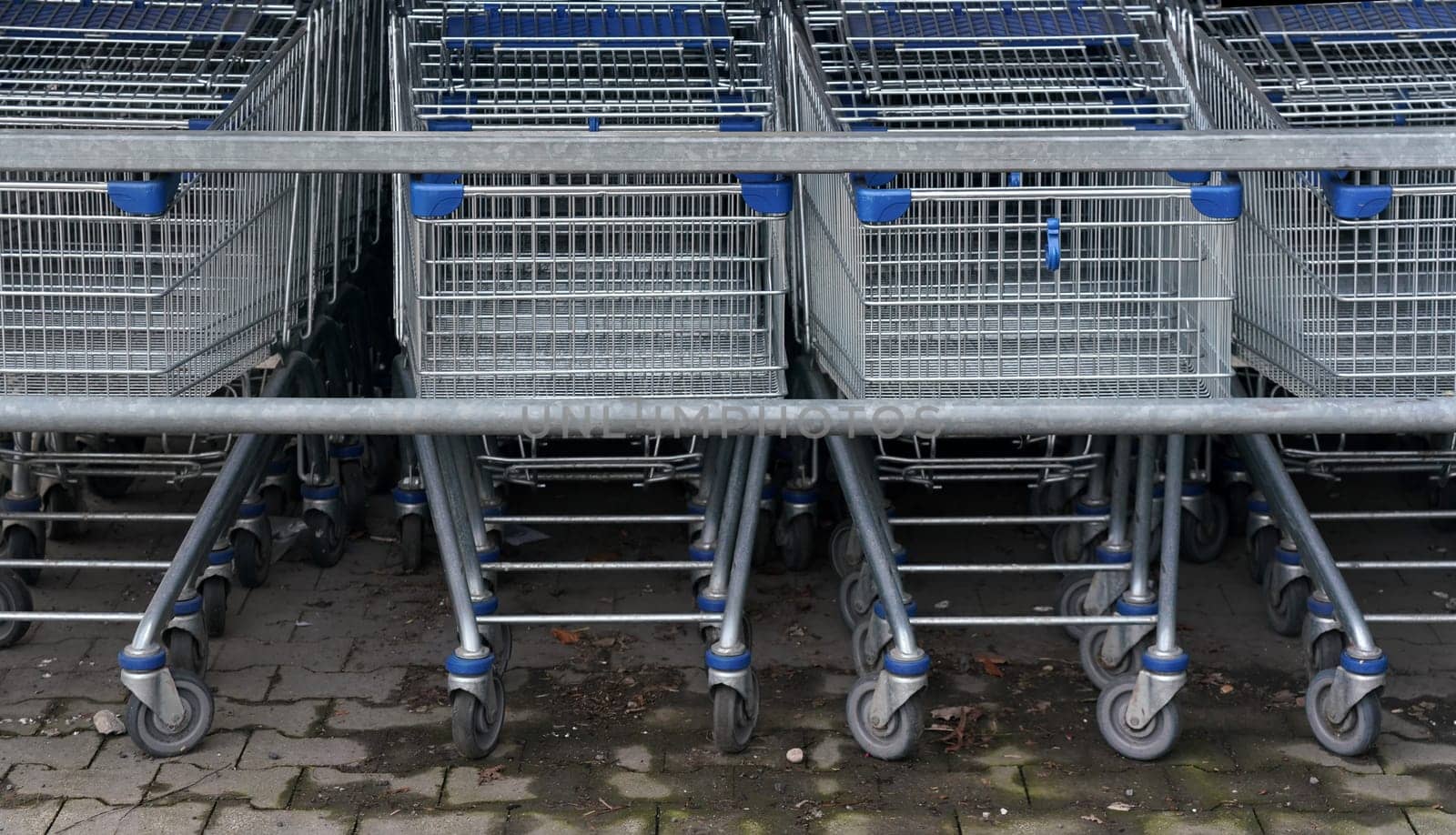Closeup of metal shopping carts stacked in front of shop mall.
