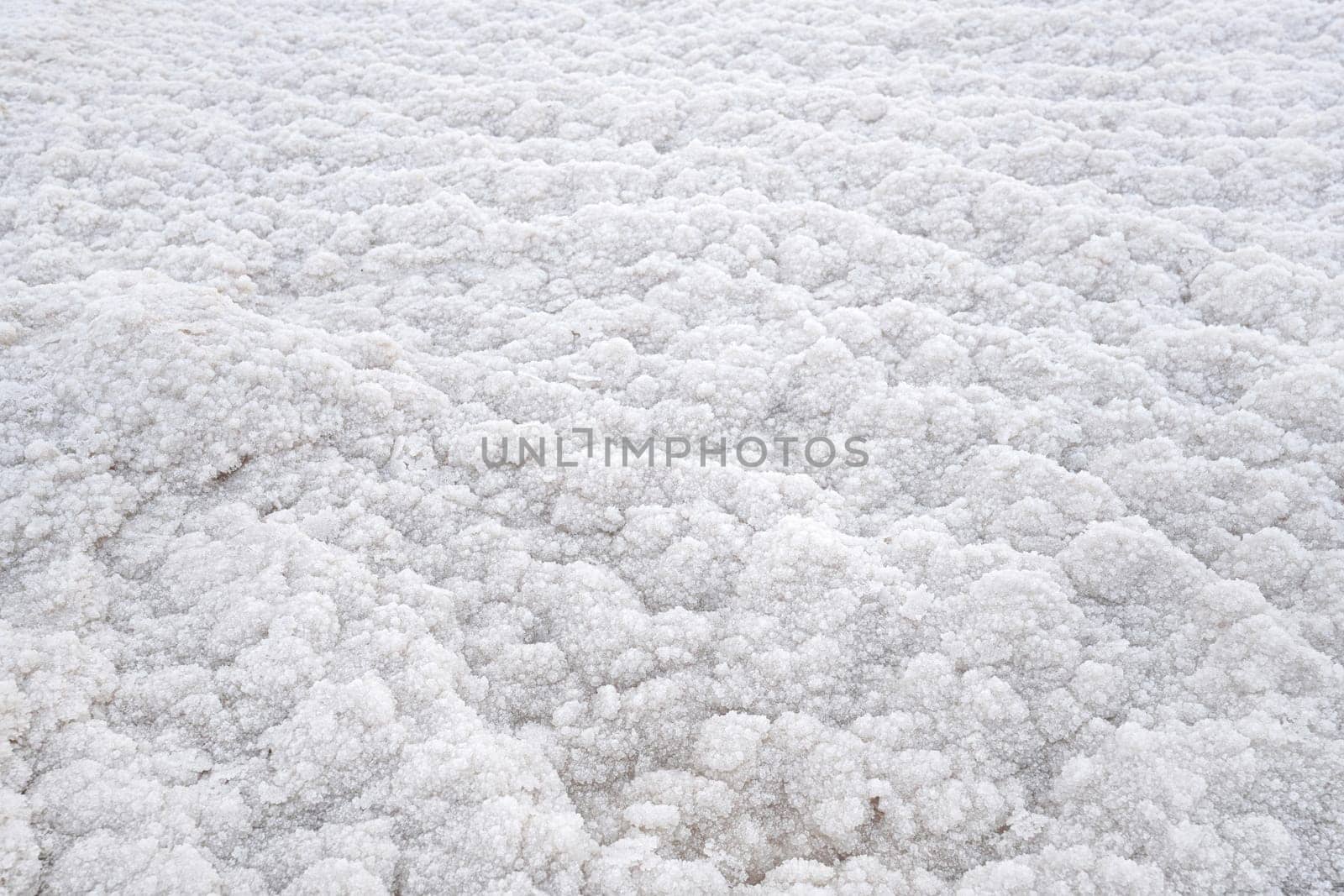 White crystalline salt closeup detail on Ein Bokek beach at Dead Sea - world most hypersaline lake.