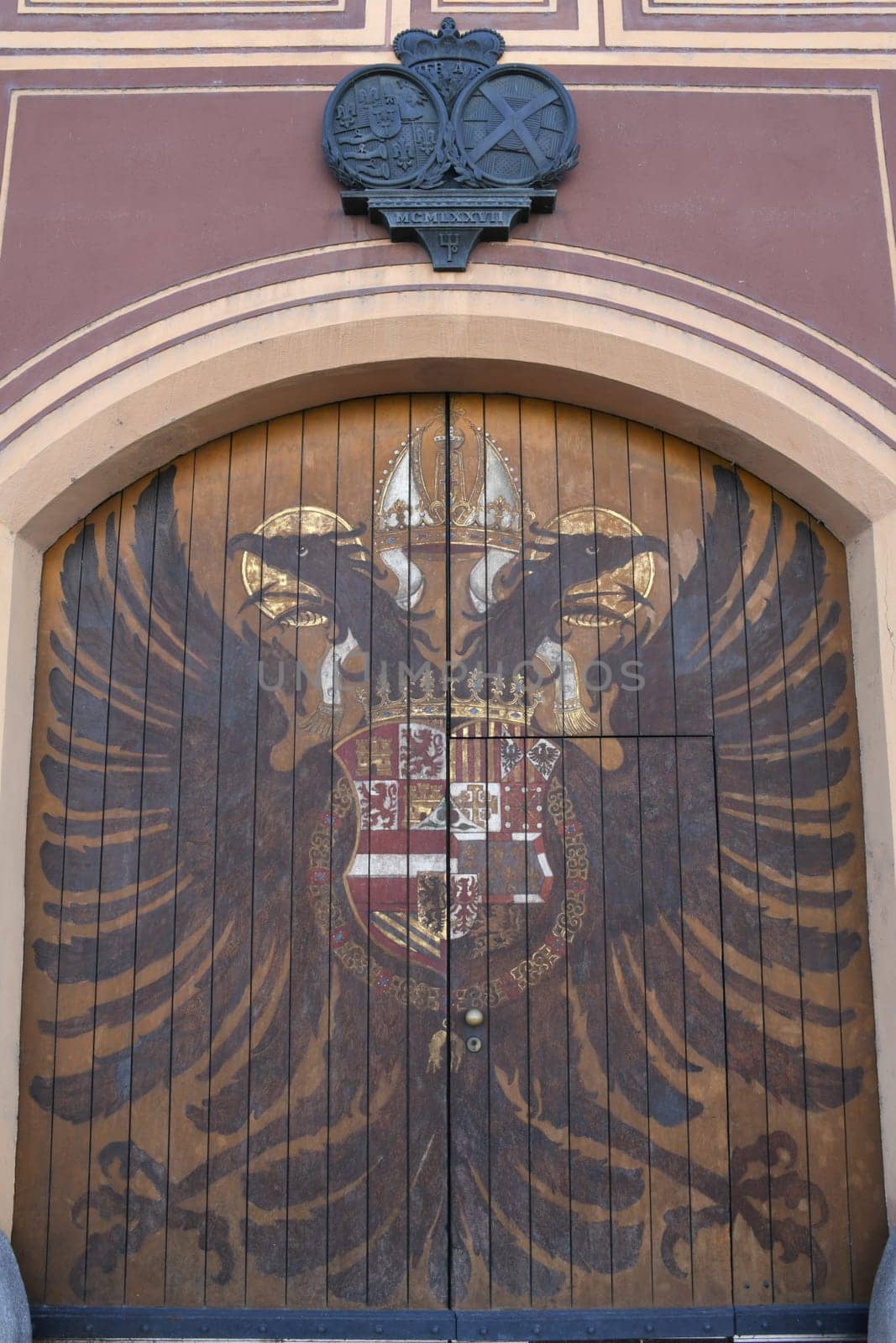 The historic Adlertor on the facade of the Fuggerei in Augsburg shows the coat of arms of an imperial double-headed eagle. It is a listed building.