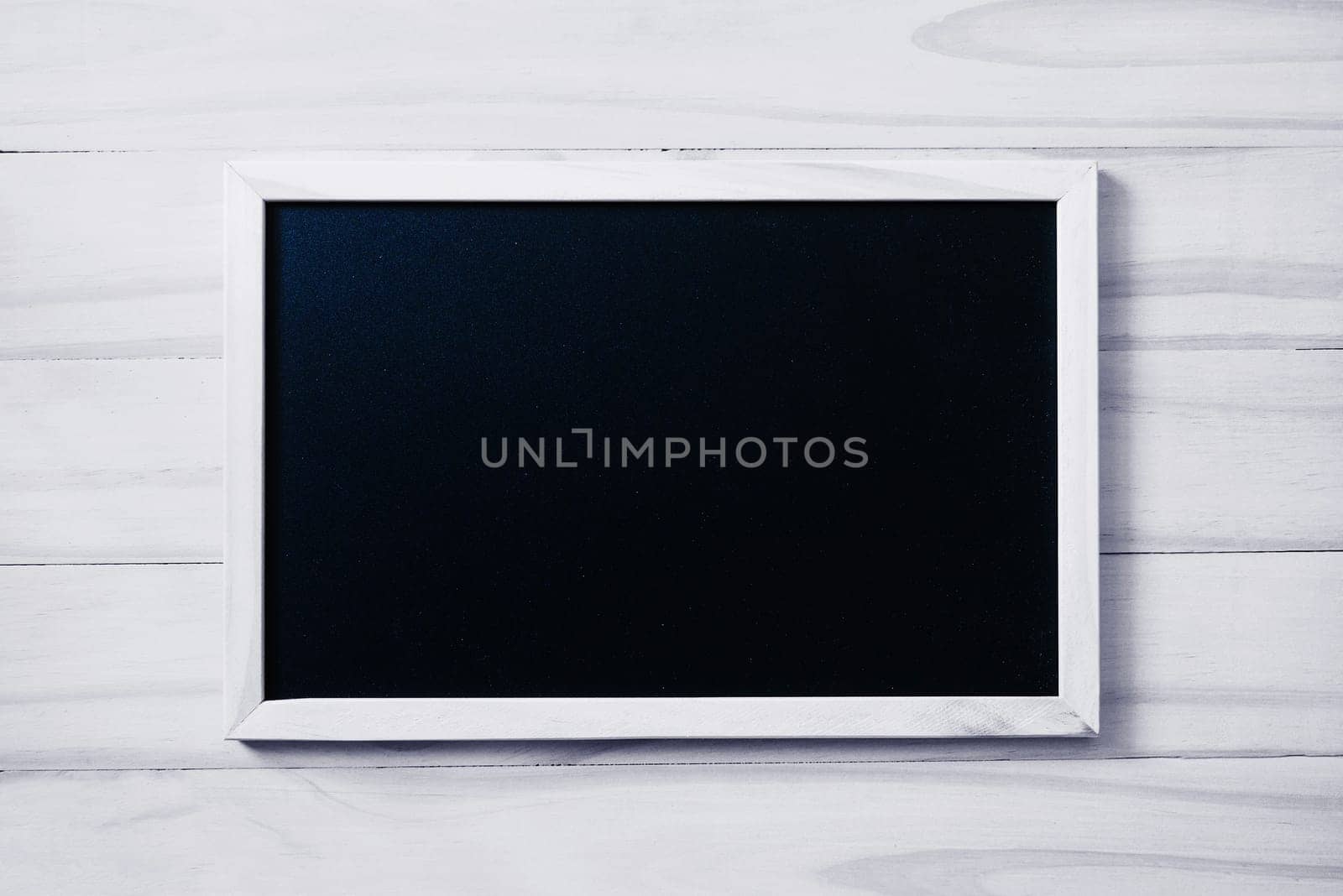 Blank blackboard on white wood background with copy space for your text.