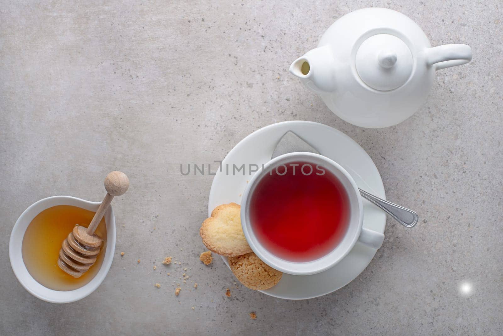 Tea cup and tea pot with fruit, herbal with honey on grey table background