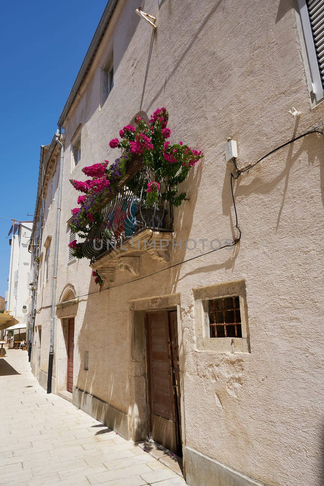 Balcony of a house in the old town of Rab in Croatia with many flowers as decoration