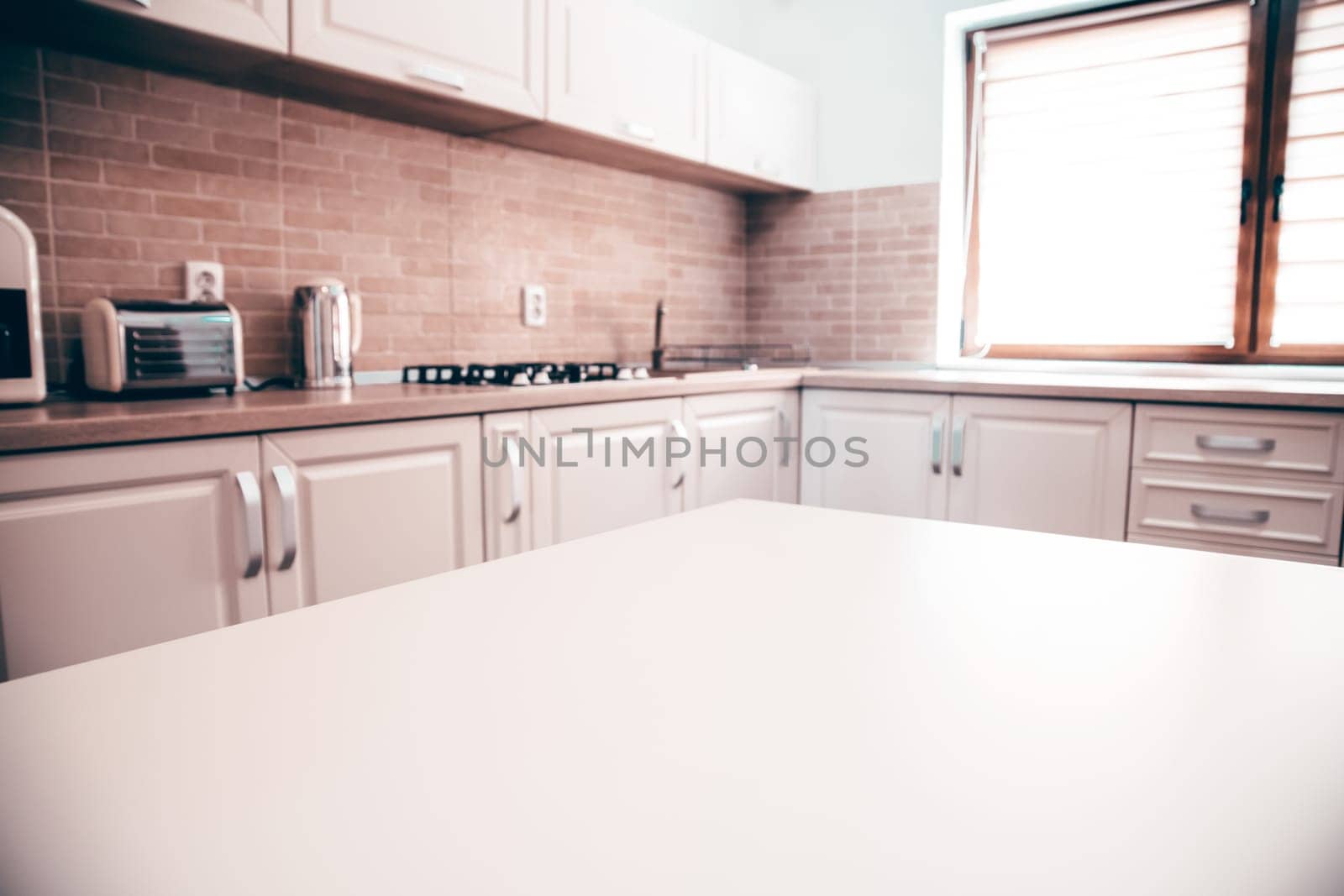 Blurred kitchen interior and white desk space. Home background