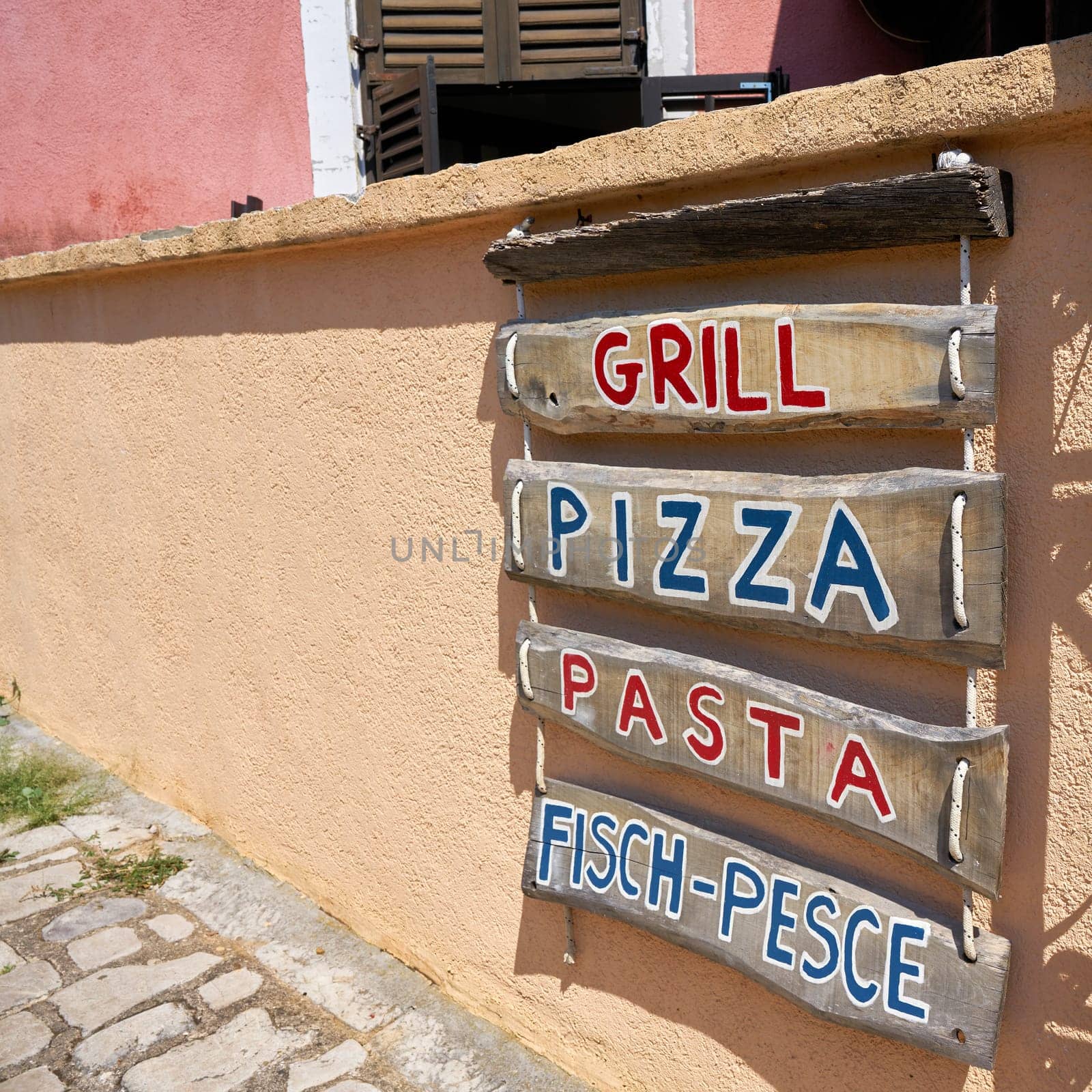 Advertisement for a typical restaurant in an alley in the old town of Krk in Croatia