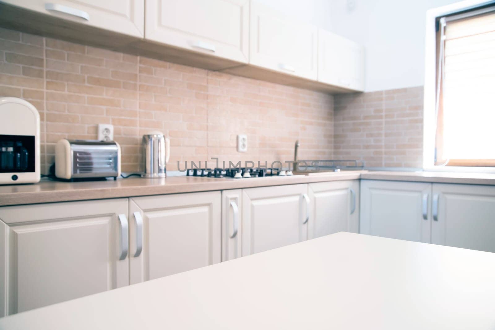 Blurred kitchen interior and white desk space. Home background