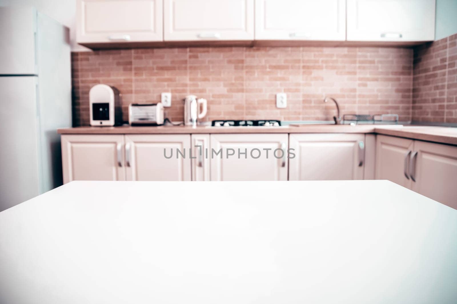 Blurred kitchen interior and white desk space. Home background