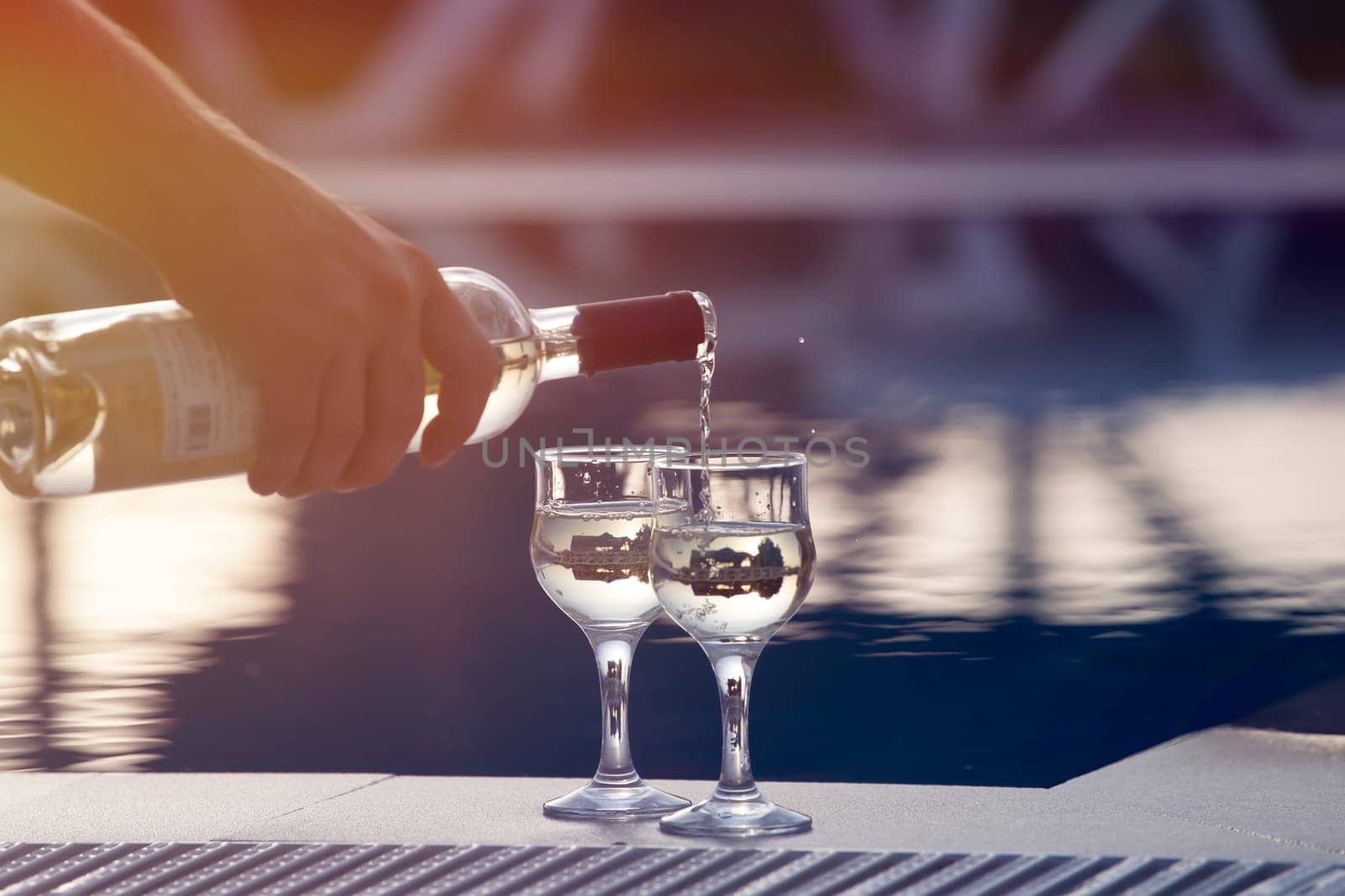 Summer party, wine in glasses near the swiming pool, summer drinks, relaxing by the water