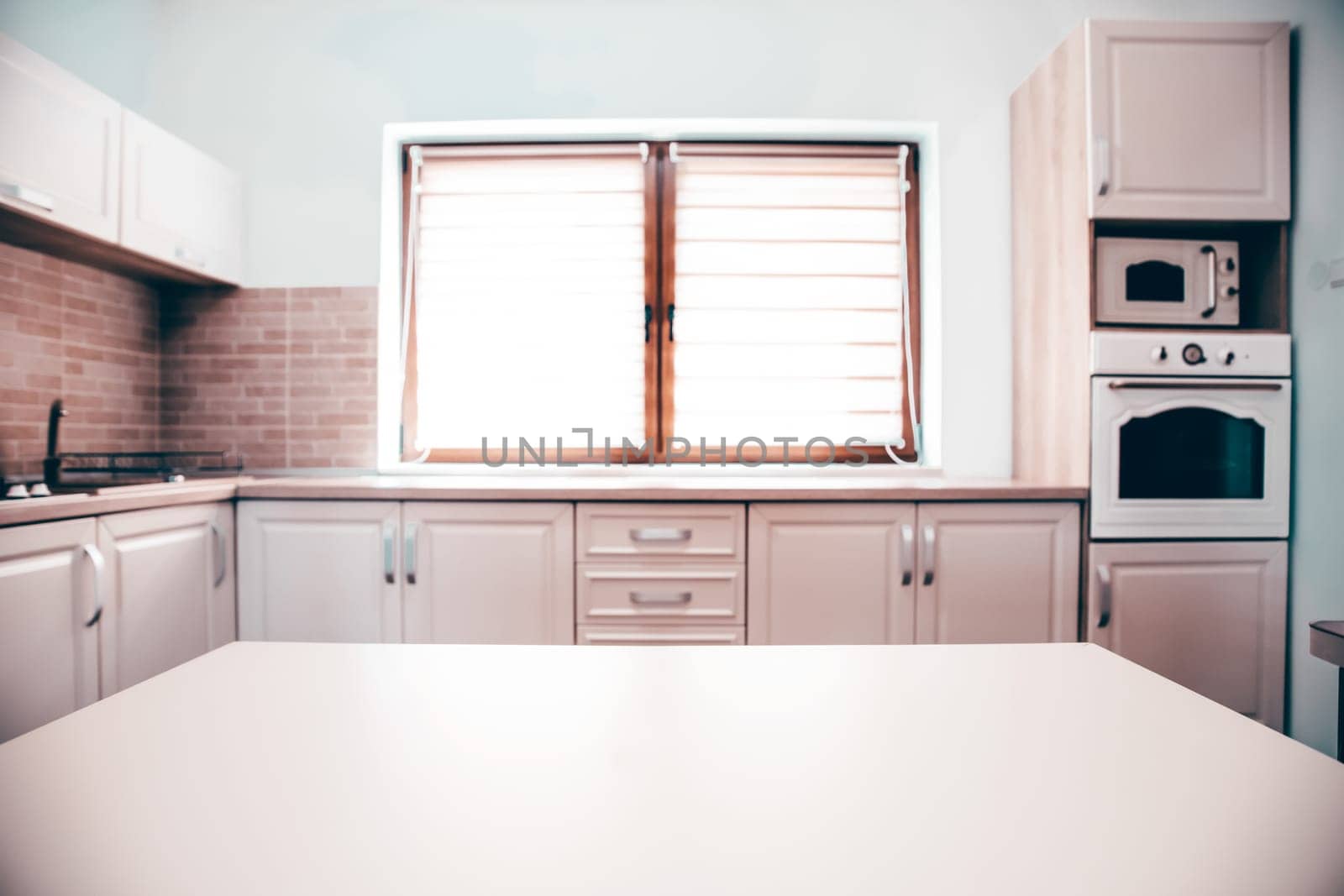 Blurred kitchen interior and white desk space. Home background