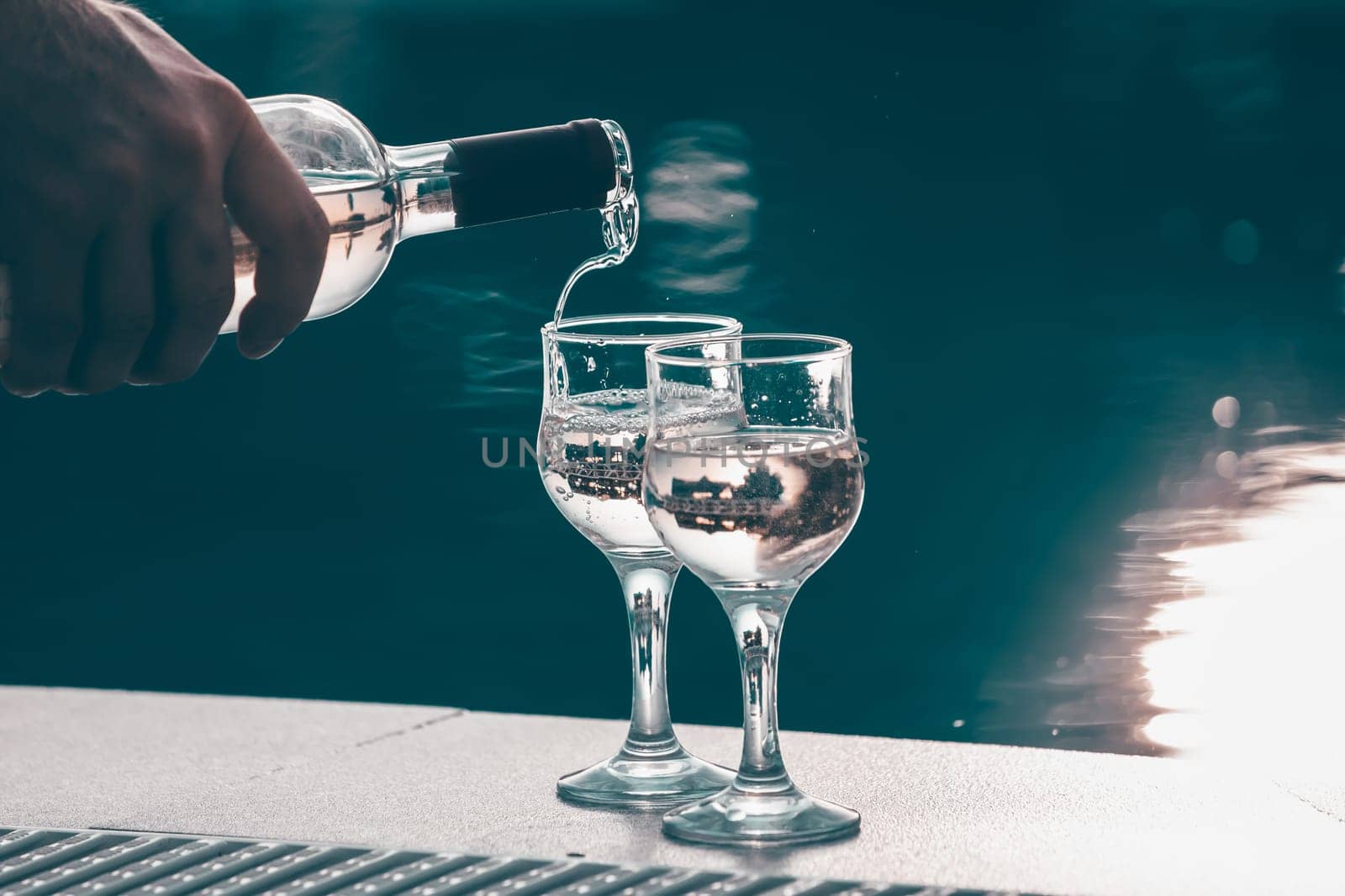 Summer party, wine in glasses near the swiming pool, summer drinks, relaxing by the water