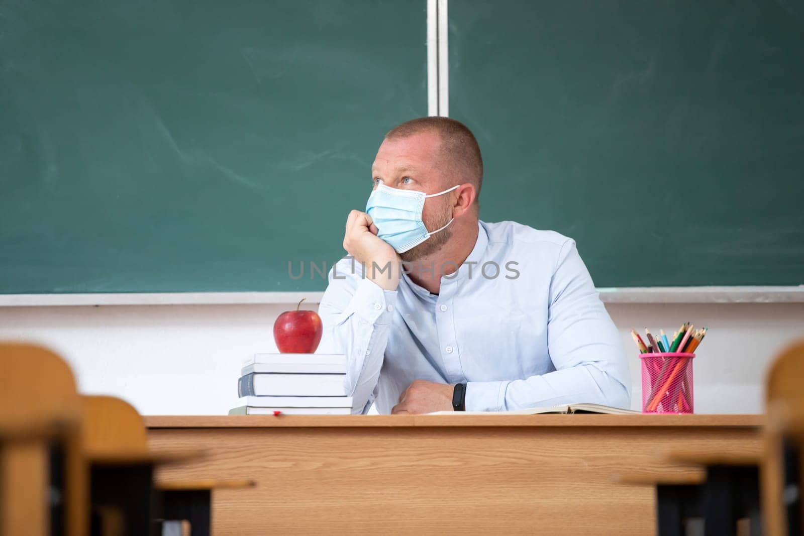 Sad school teacher because of coronavirus isolation. Concept of problems due to the flu virus pandemic at school