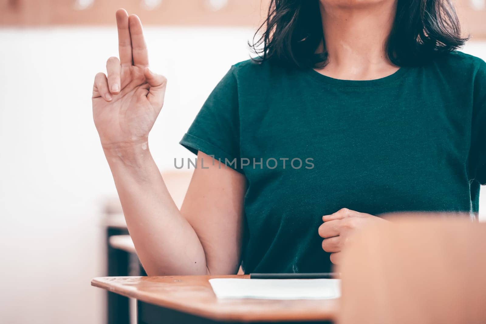 High school or university student holding pencil writing on paper answer sheet. Final exam concept.