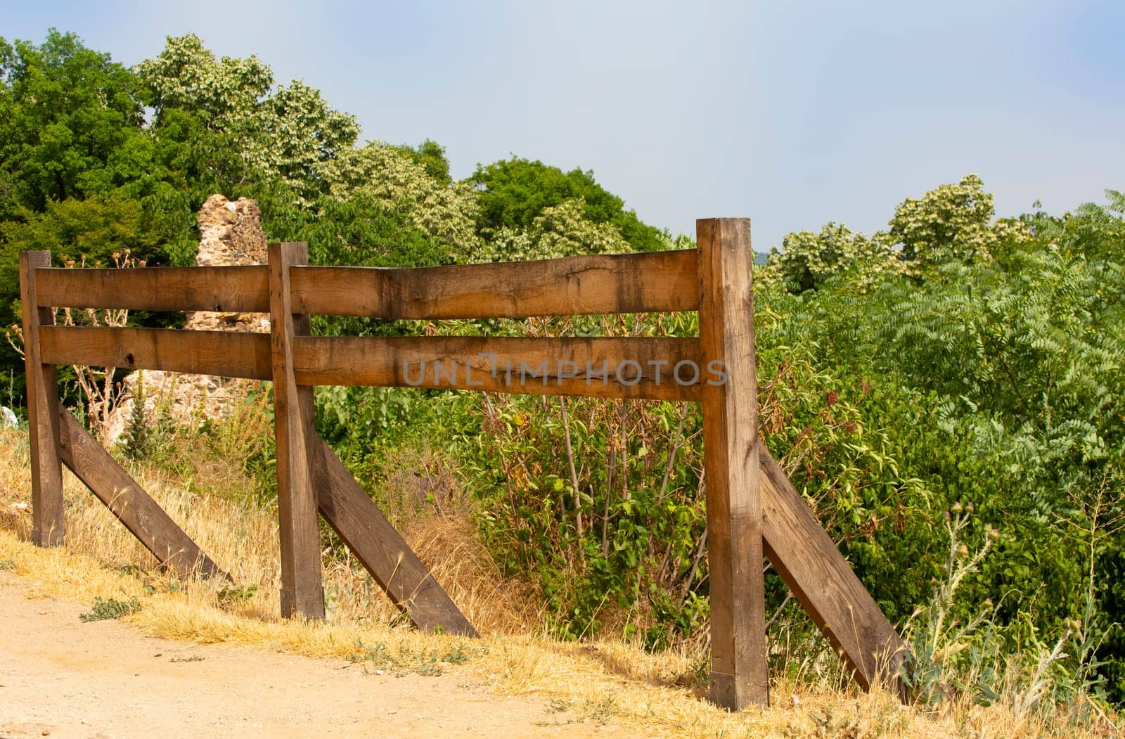 The wooden fence in a mountainous area in summer on a sunny day
