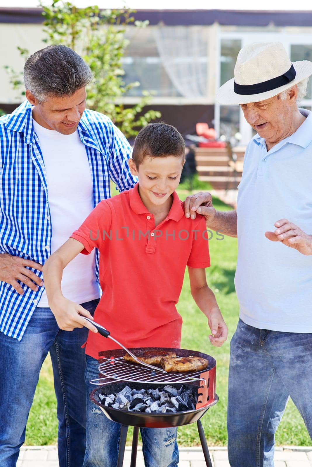Modern senior man, young man and boy cooking barbecue