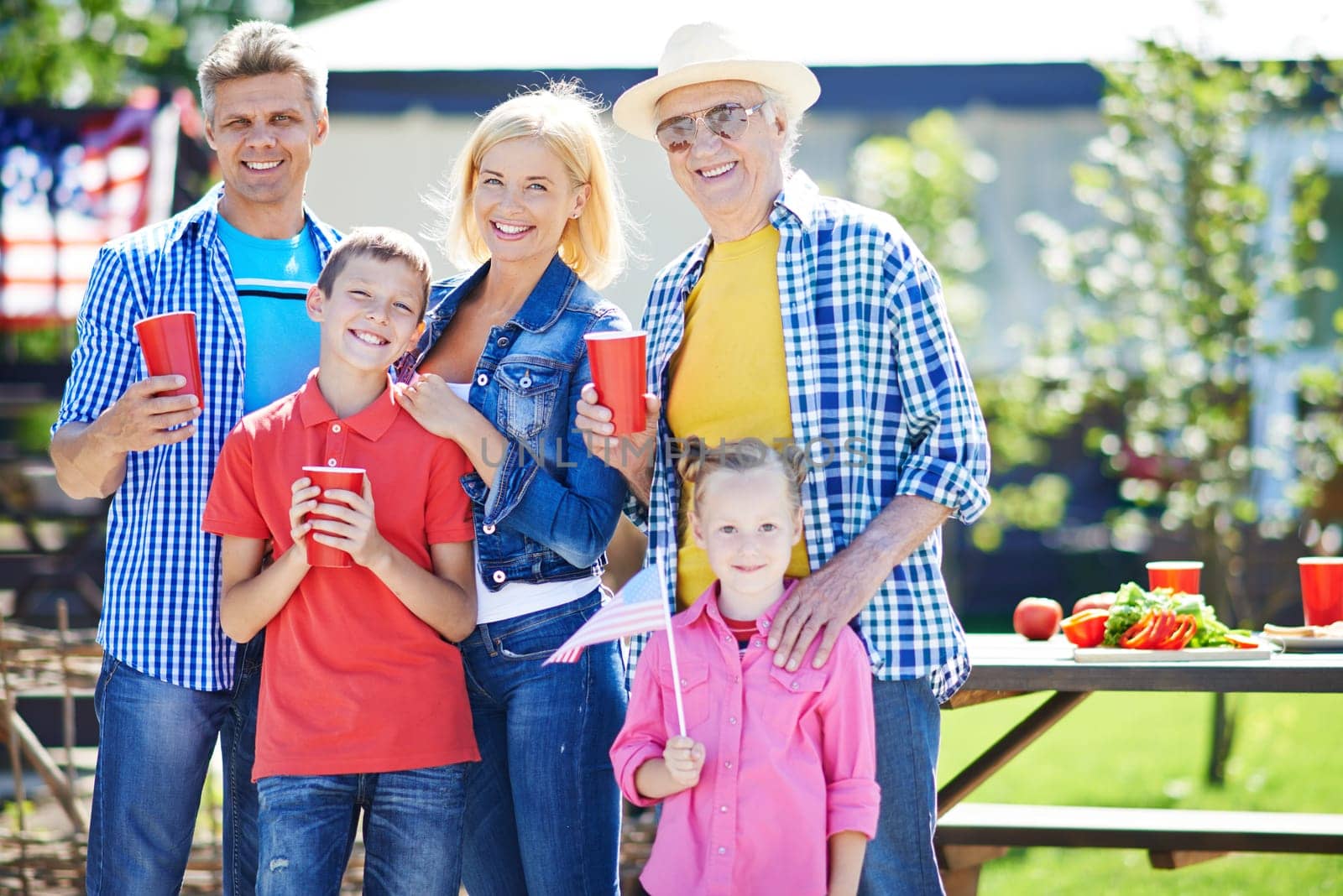 Happy senior man and young couple with two kids spending weekend outdoors