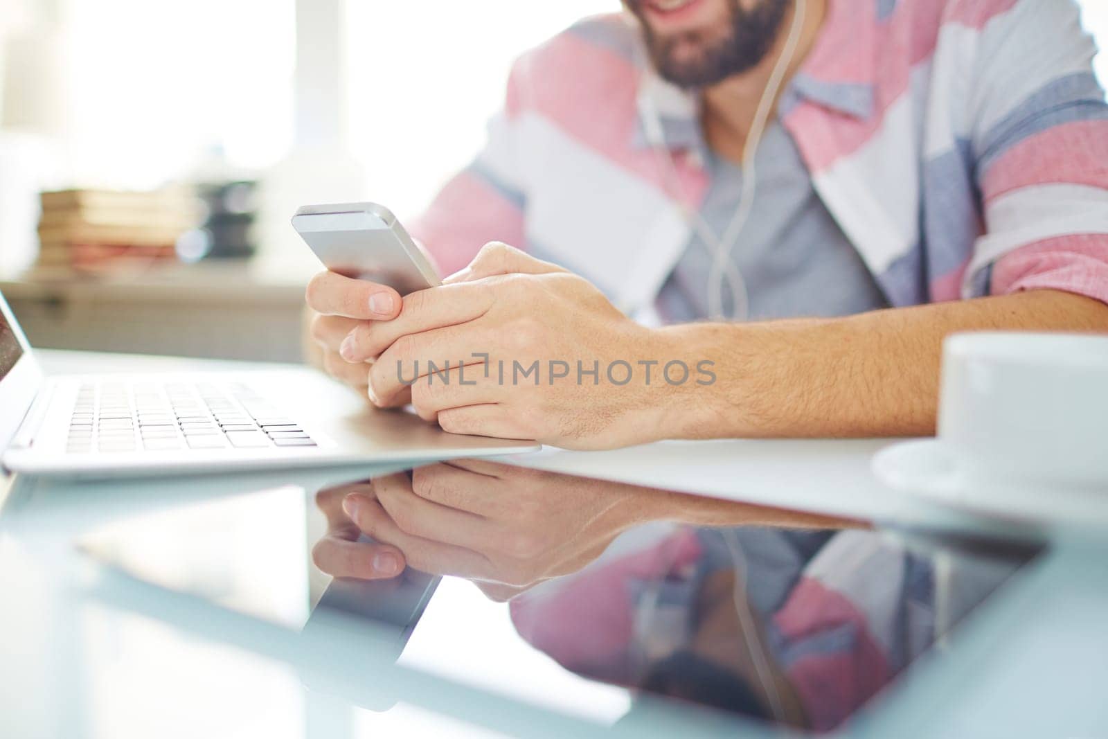 Modern gadgets on workplace and male hands with smartphone