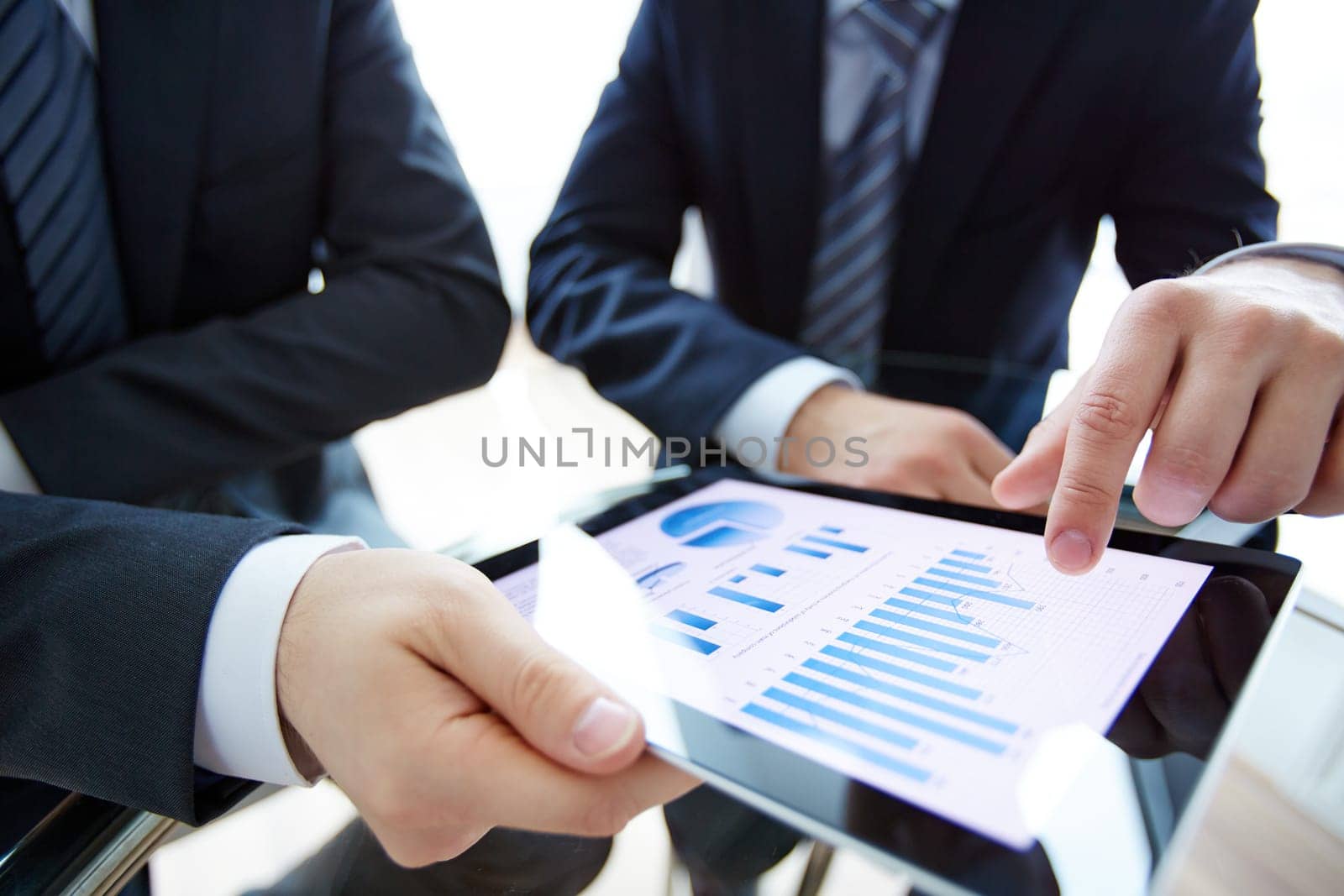 Business document in touchpad and hands of male employees during discussion of data