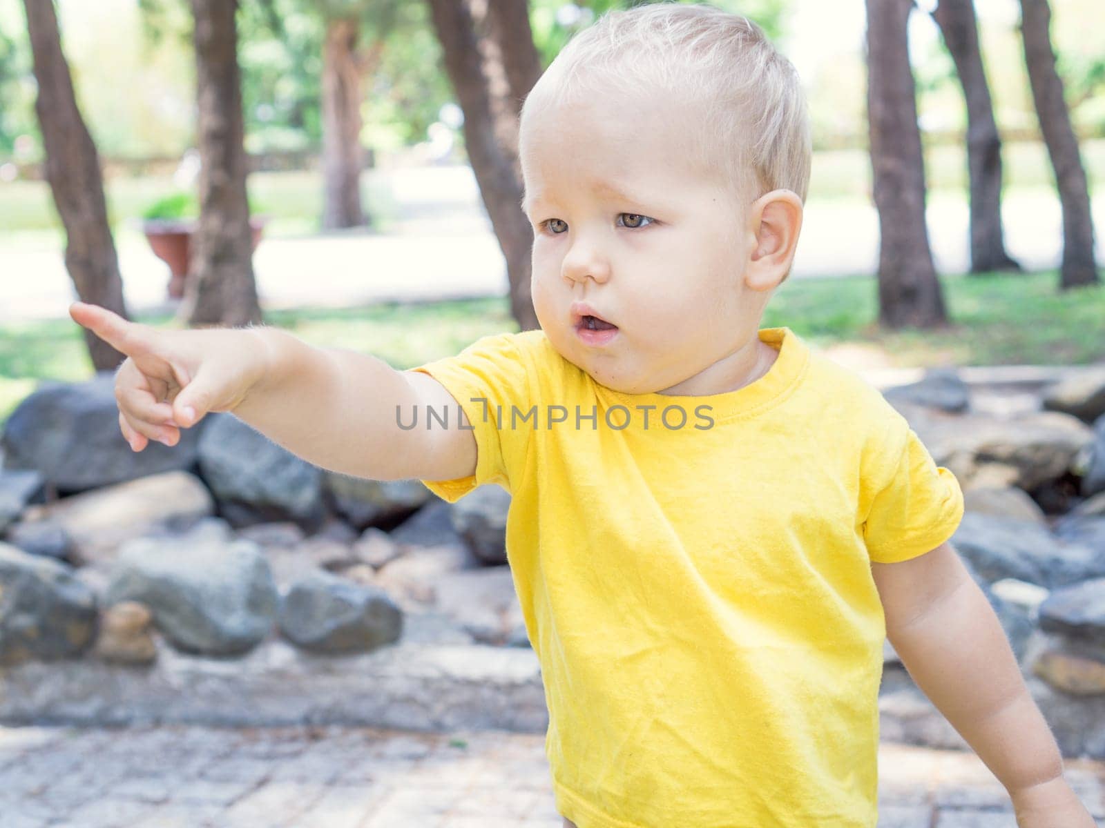 Outdoor portrait of the cute baby pointing
