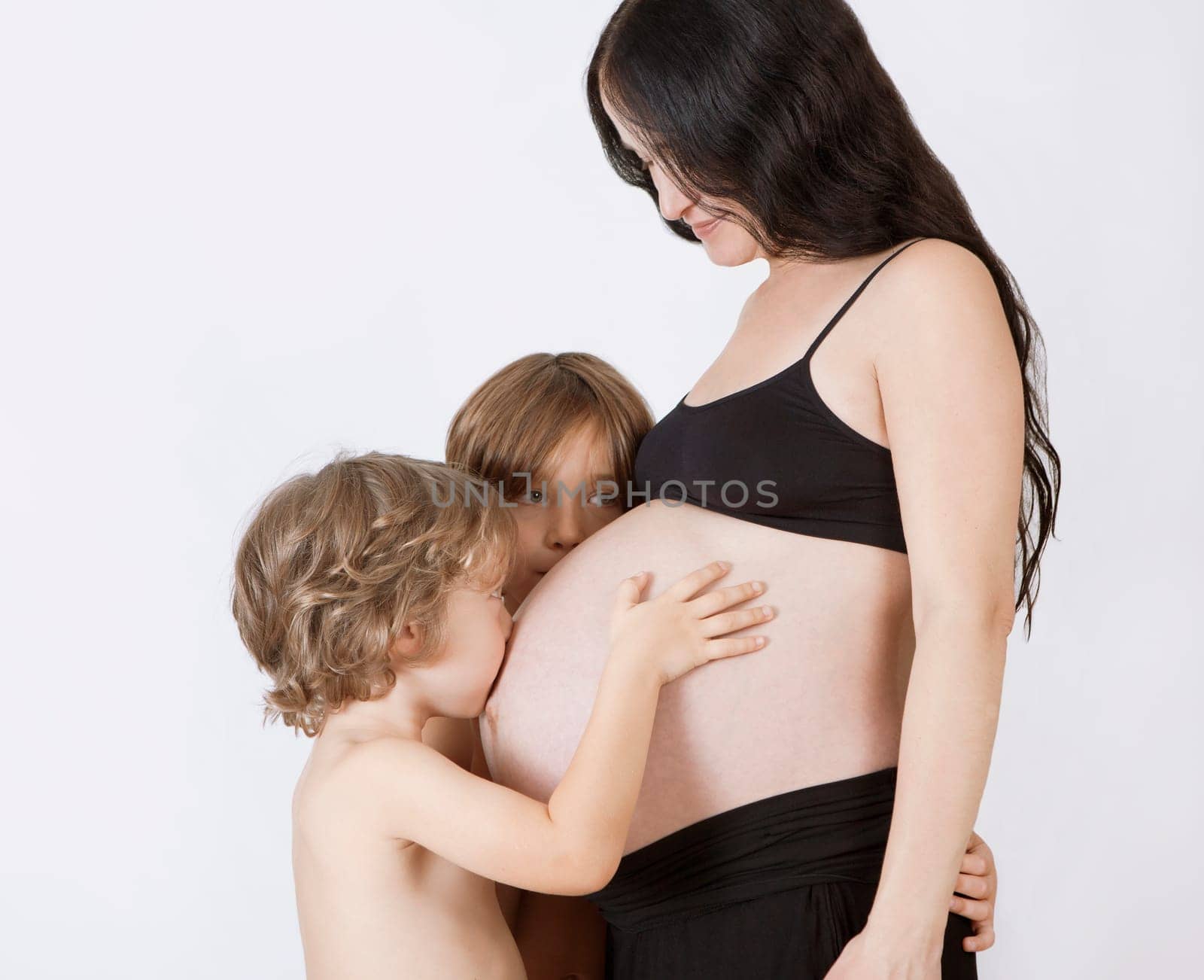 a woman with baby belly and two young children waiting for the birth