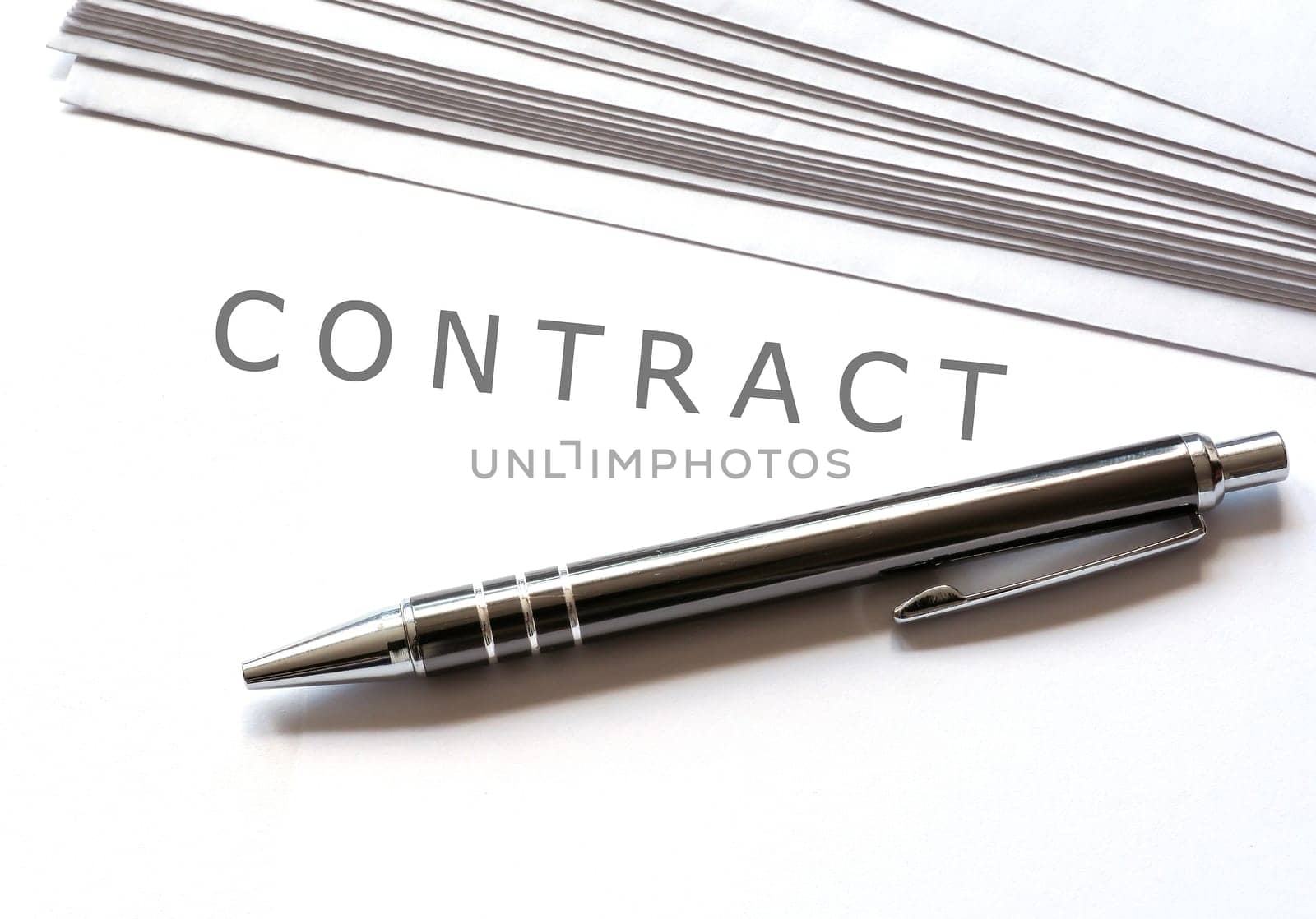 a contract and a ballpoint pen are on a desk