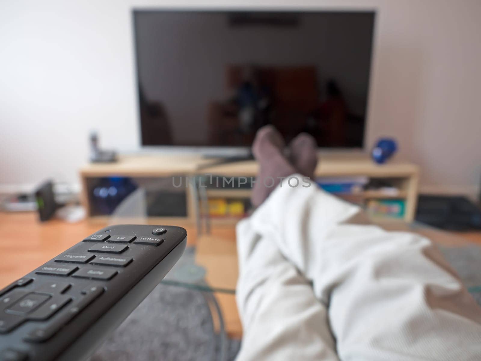 Man with remote control in front of the TV