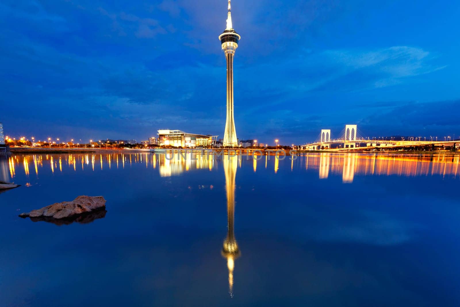 Urban landscape of Macau with famous traveling tower under sky near river in Macao, Asia.