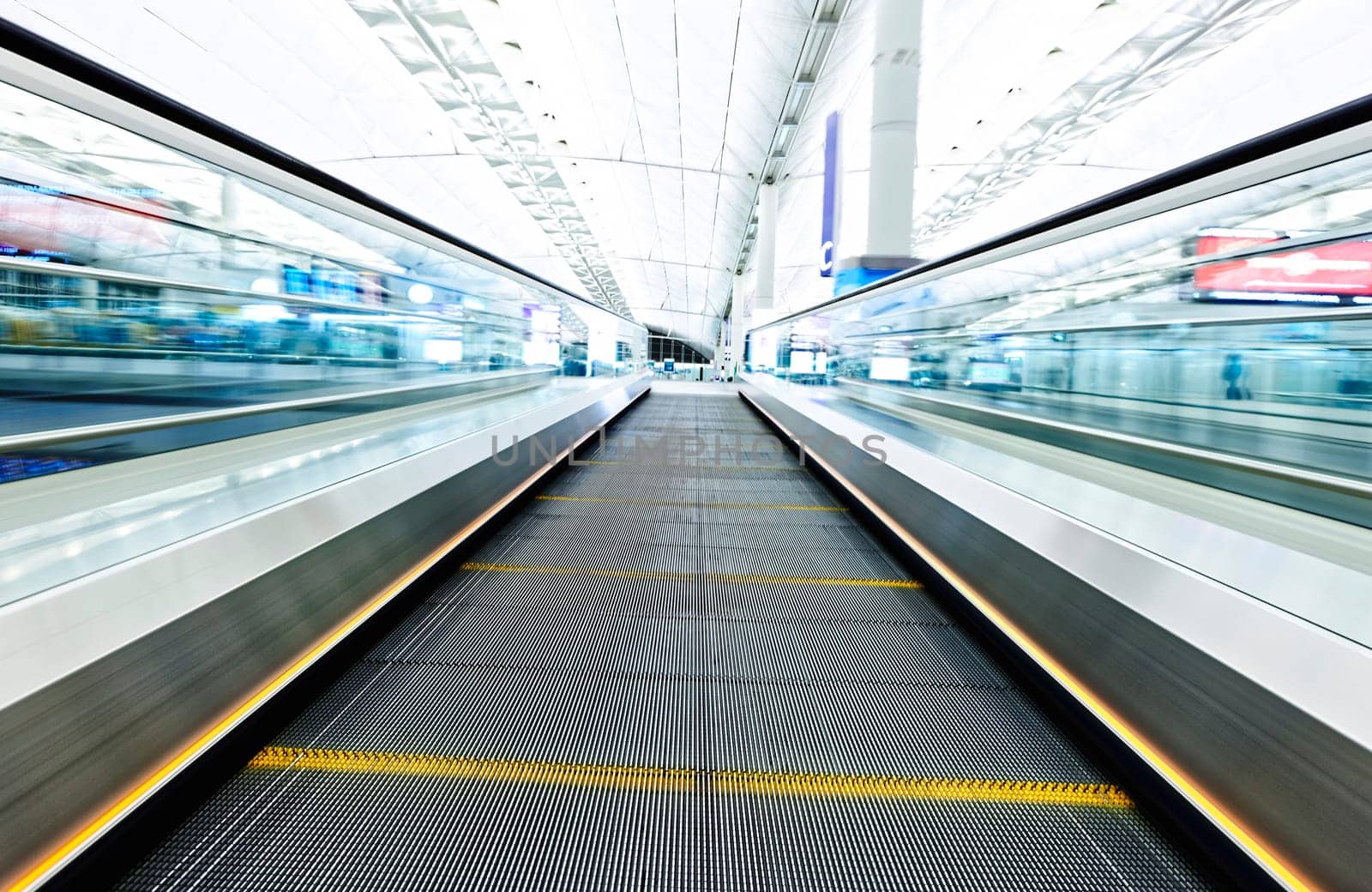 symmetric moving blue escalator inside contemporary airport, hong kong