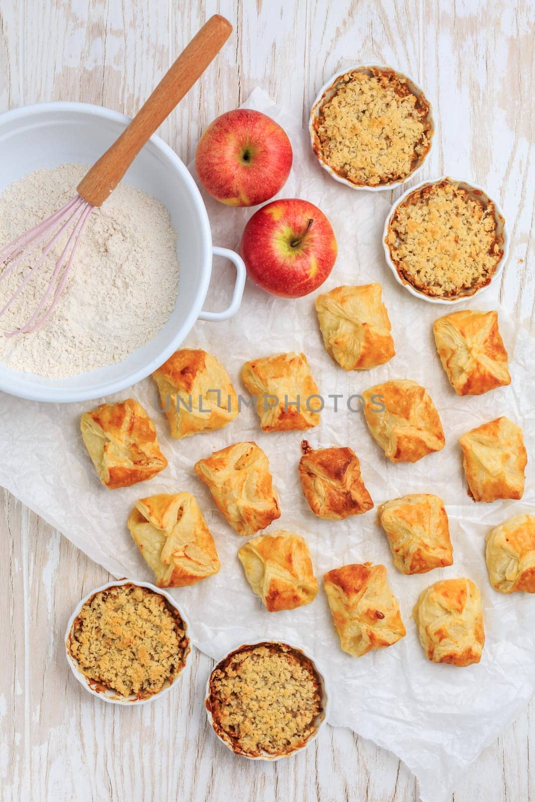 Homemade apple turnovers and small apple crumble cakes with ingredients