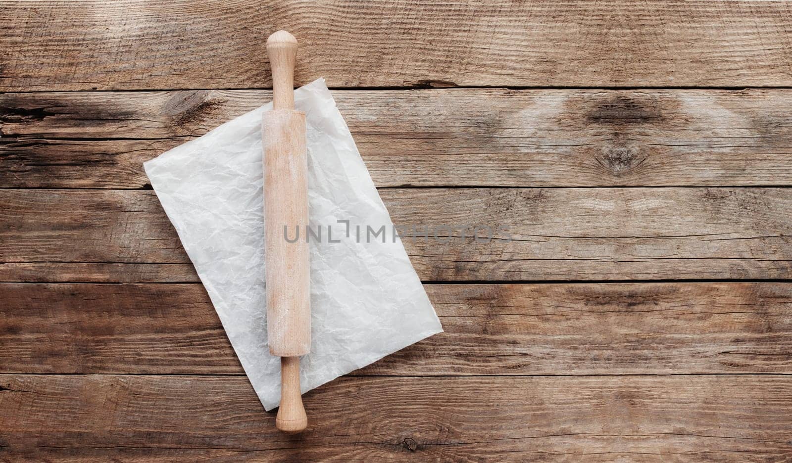 Ingredients for baking and kitchen utensils on old wooden background. Cooking baking dough, preparing flour, rocking pin, parchment paper. Baking concept flat lay photo with copy space