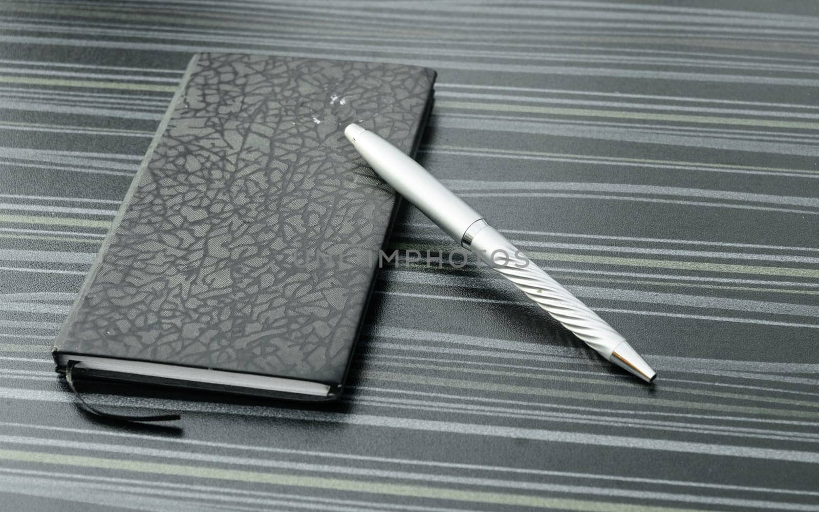 Pen and notebook on office table. Table top view. Corporate business background.