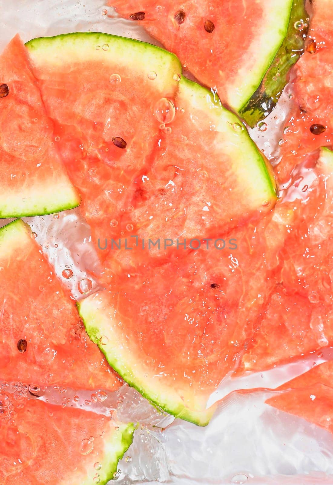 Close up view of the red melon slices in lemonade background. Texture of cooling sweet summer's drink with macro bubbles on the glass wall. Flat design.