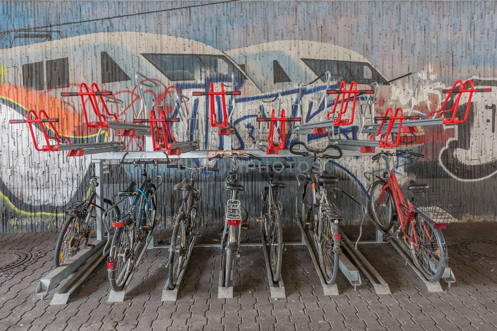 Bicycles on the bike stand in front of a graffiti wall