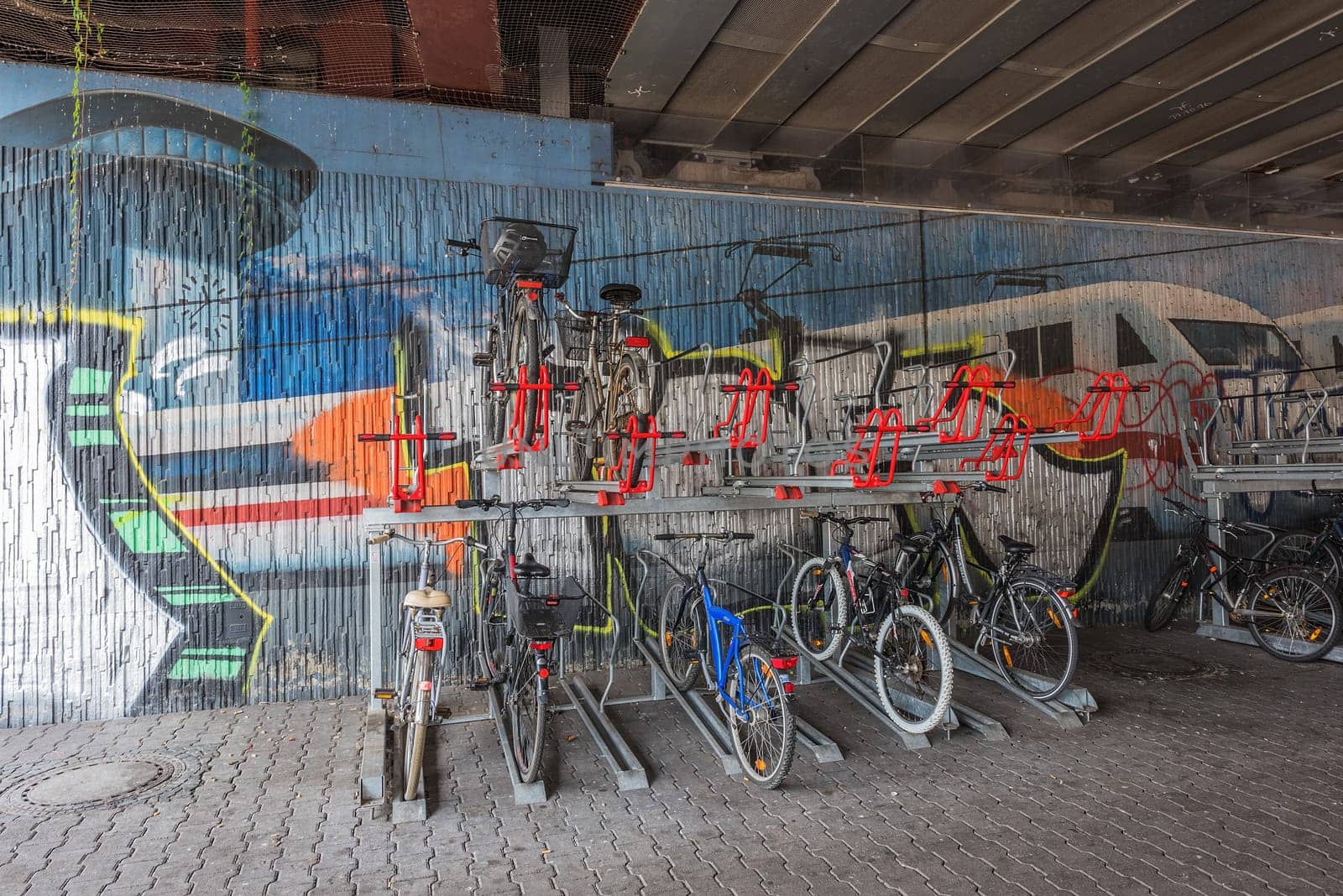 Bicycles on the bike stand in front of a graffiti wall