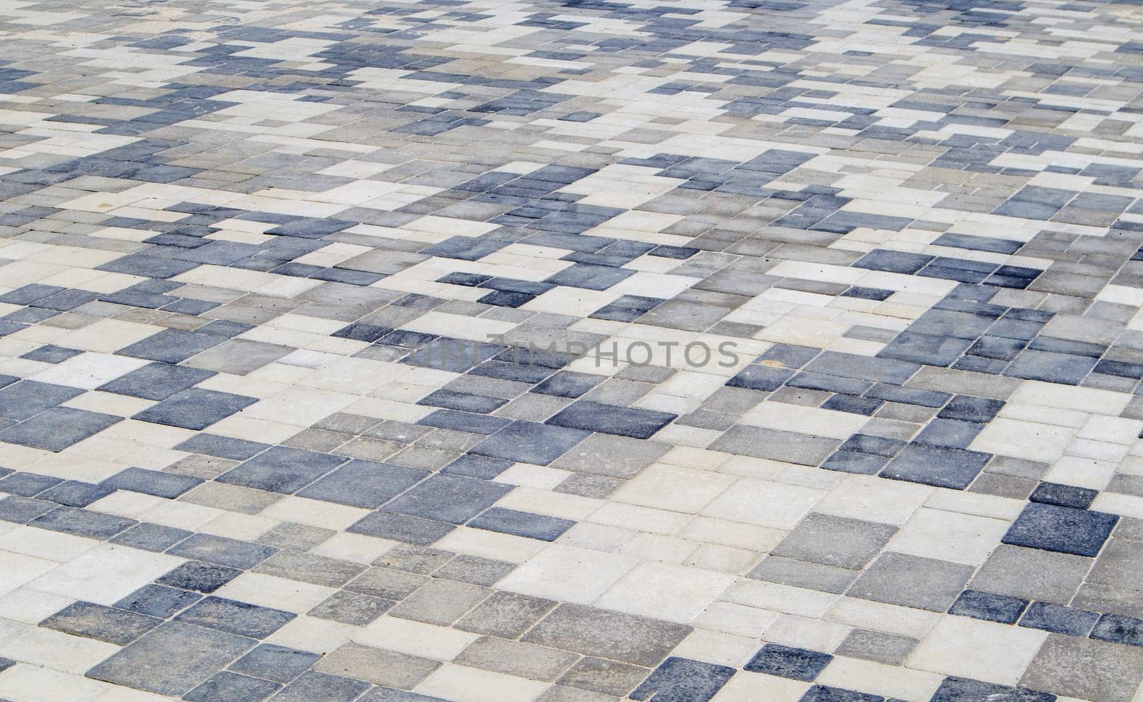 Concrete or paved newly laid gray paving slabs or stones for floors or walkways. Concrete paving slabs in the backyard or road paving. Garden brick path in the courtyard on a sandy foundation