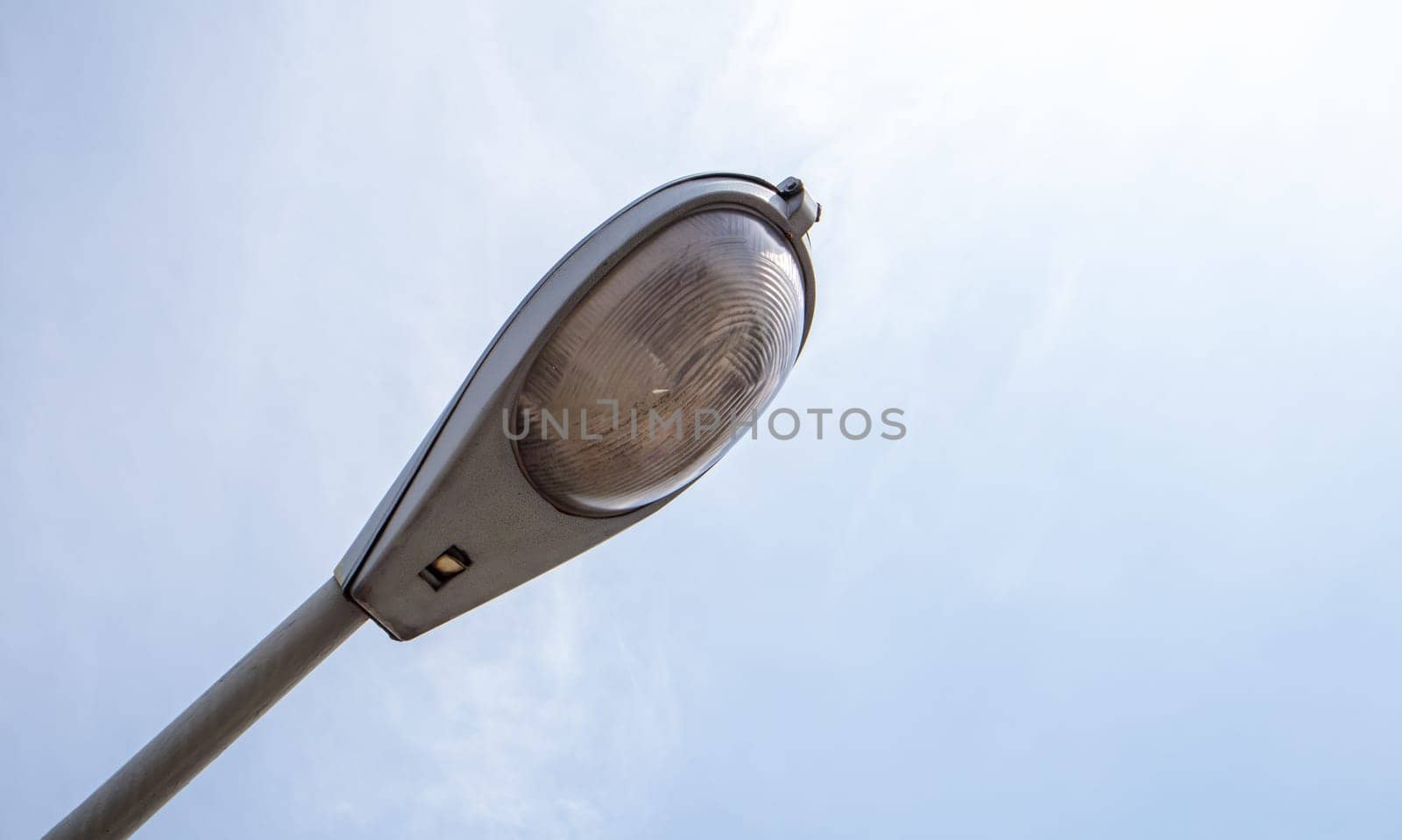 Street lamp close up. Big street lights at a big highway interchange. Close-up. Modern street lamp. Electric old lamp of street lighting on the background of blue sky and clouds during the day