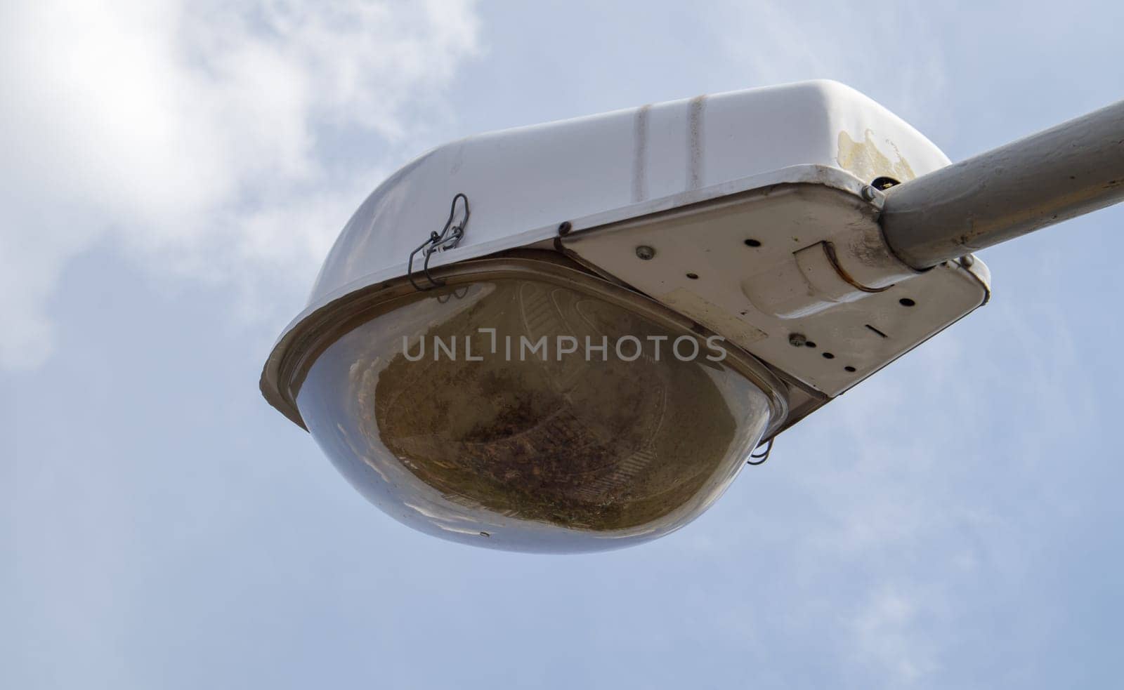 Street lamp close up. Big street lights at a big highway interchange. Close-up. Modern street lamp. Electric old lamp of street lighting on the background of blue sky and clouds during the day