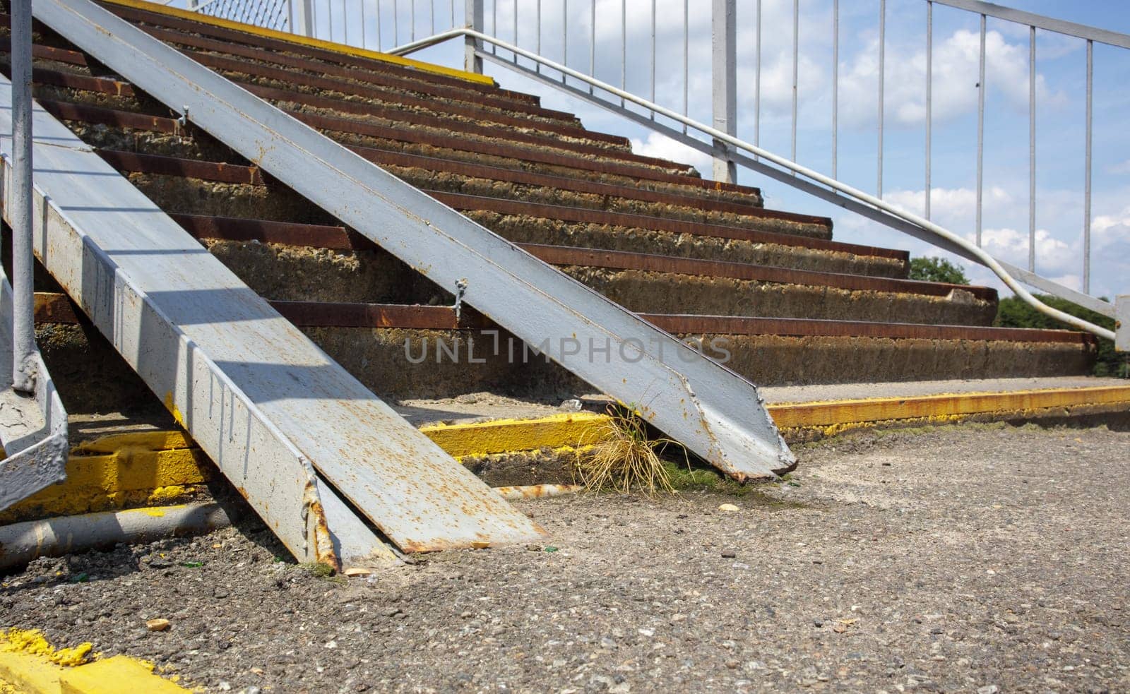 The staircase of the pedestrian crossing with traces of destruction. Two wheelchair rails. Metal railings for bicycles, wheelchairs and strollers with children. Special equipment on the stairs