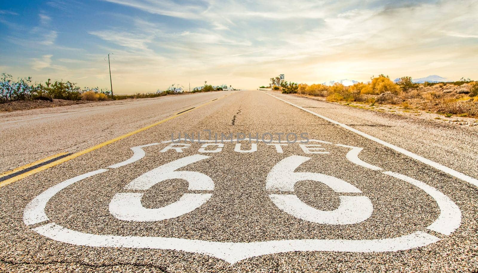 Route 66 road sign with blue sky background. Historic street with nobody. Classic concept for travel and adventure in a vintage way.
