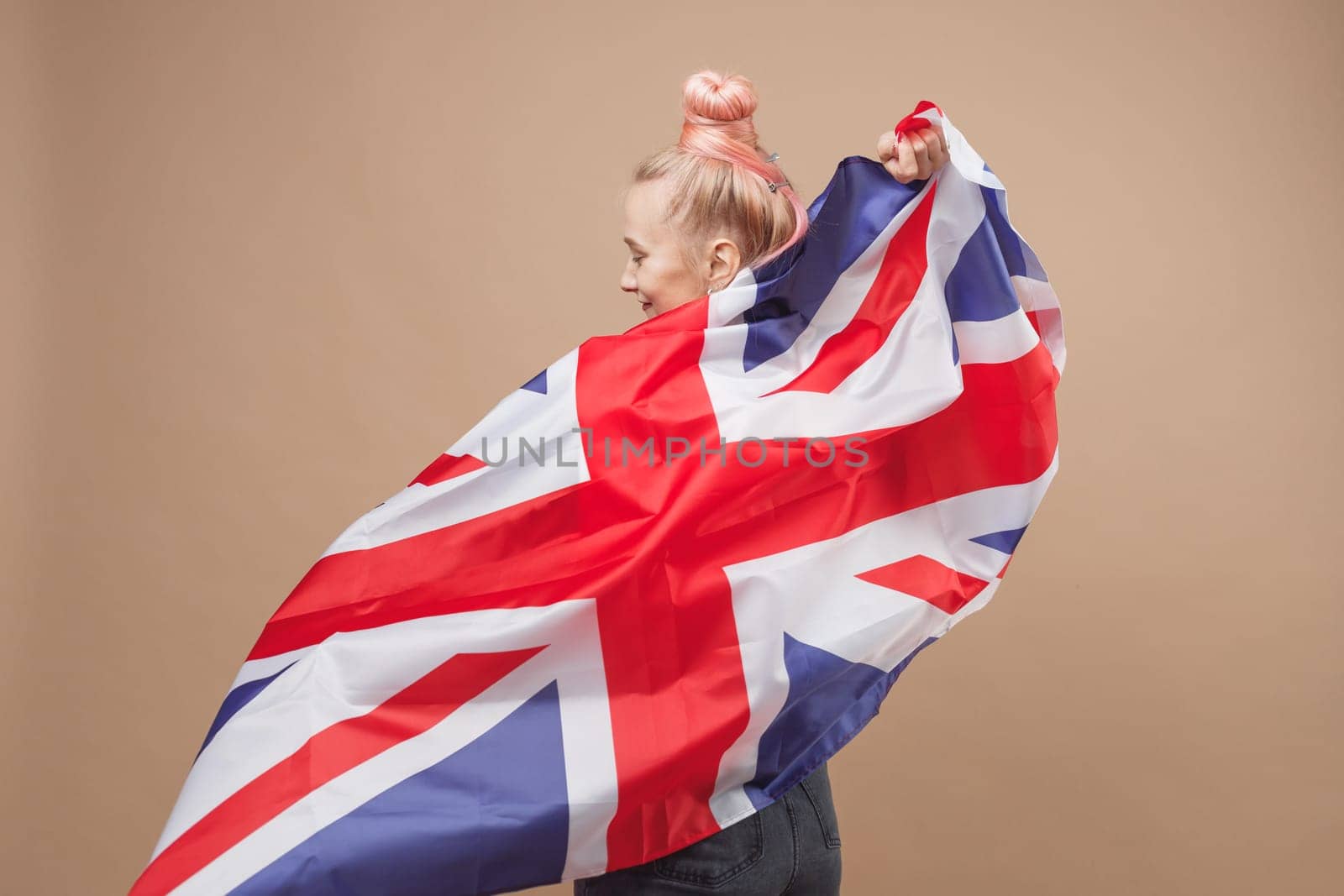 Young caucasian hipster woman with flag of Great Britain. Studio shot