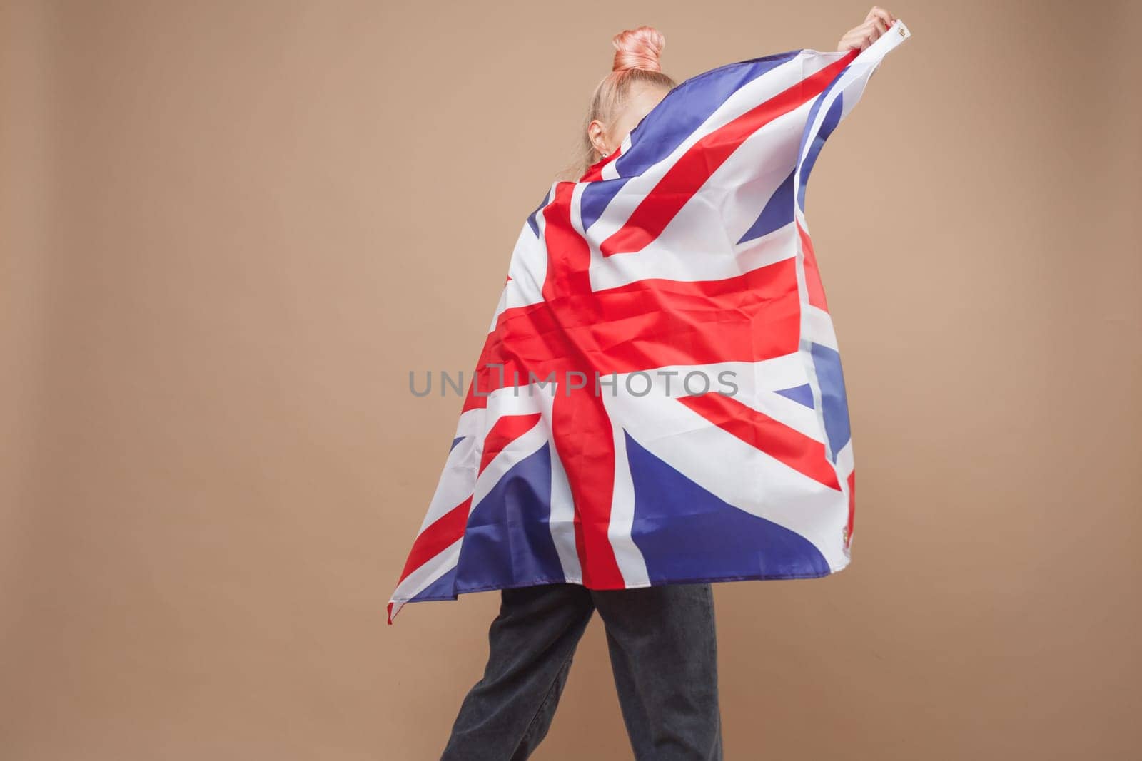 Young caucasian hipster woman with flag of Great Britain. Studio shot