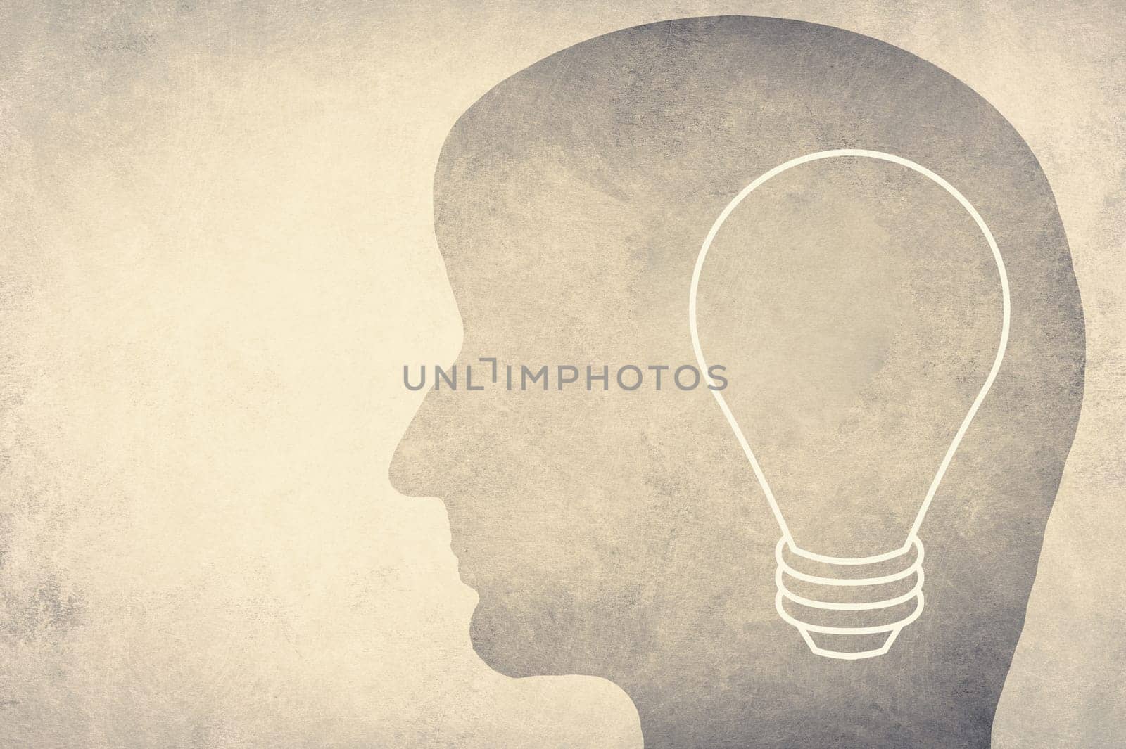 Silhouette of a face with a lightbulb, textured background, empty copy space for text