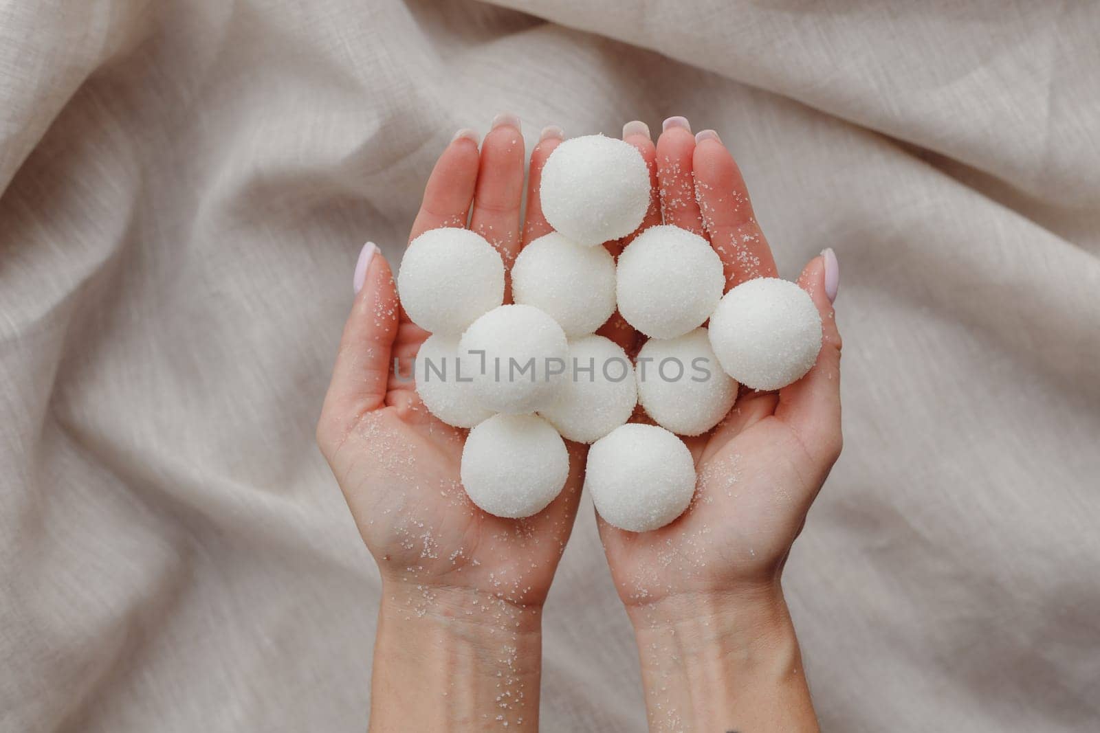 Female hands holding solid handmade natural shampoo or sugar scrub balls. Top view